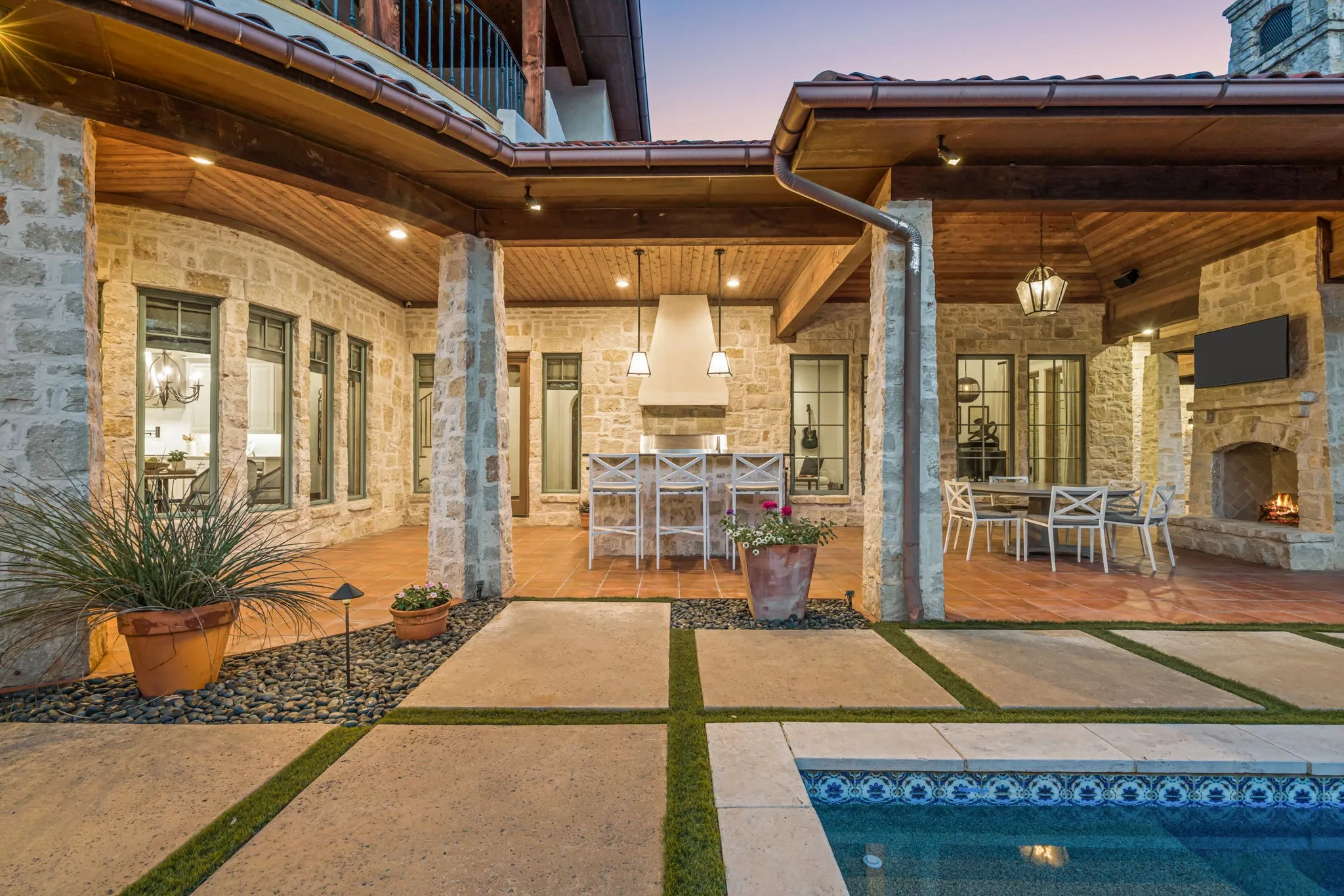 Pavers, Wolf gas grill with hood and bar island with seating; gas starter wood burning fireplace.