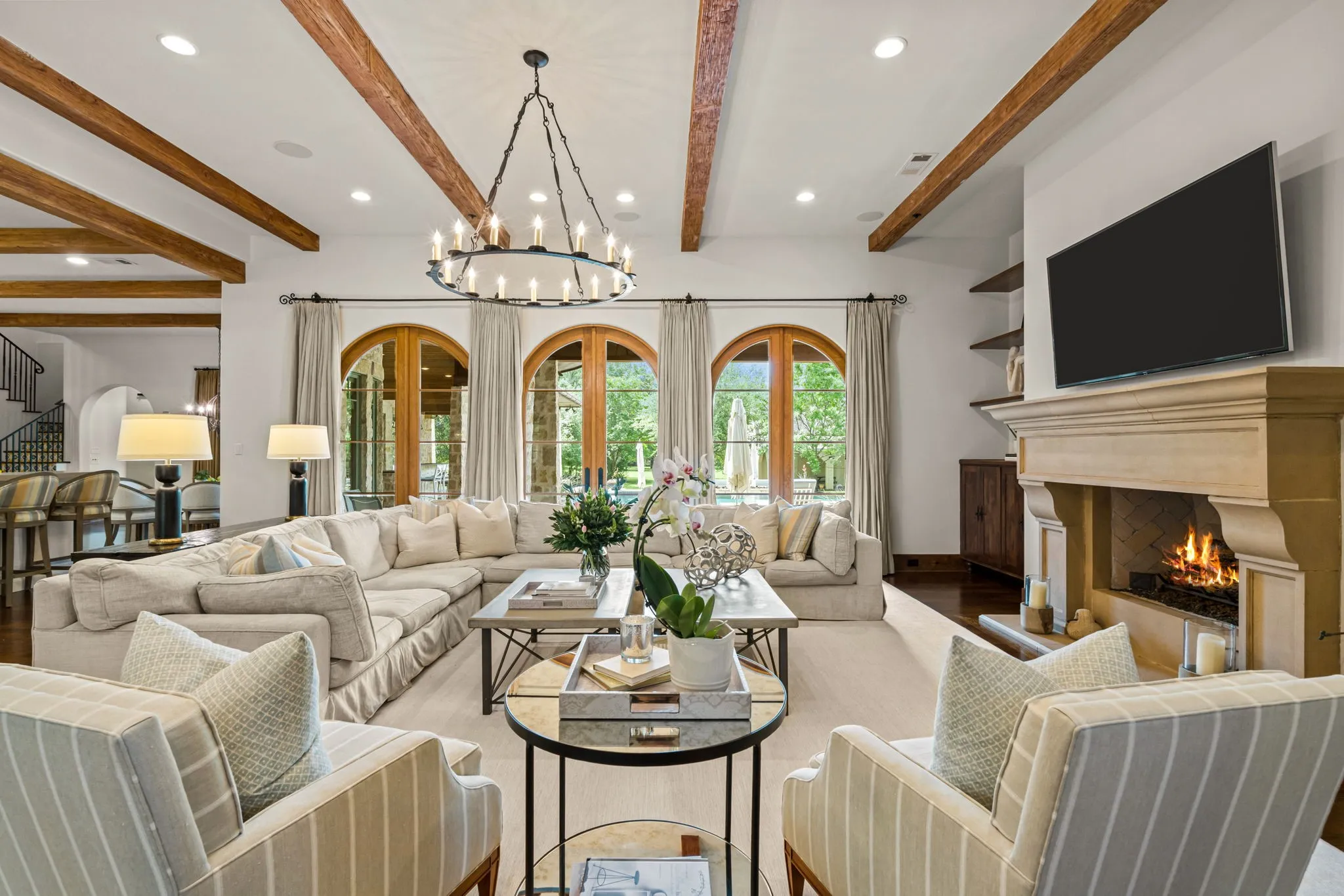 The living room connects the entry to the kitchen and the outdoor living with pool