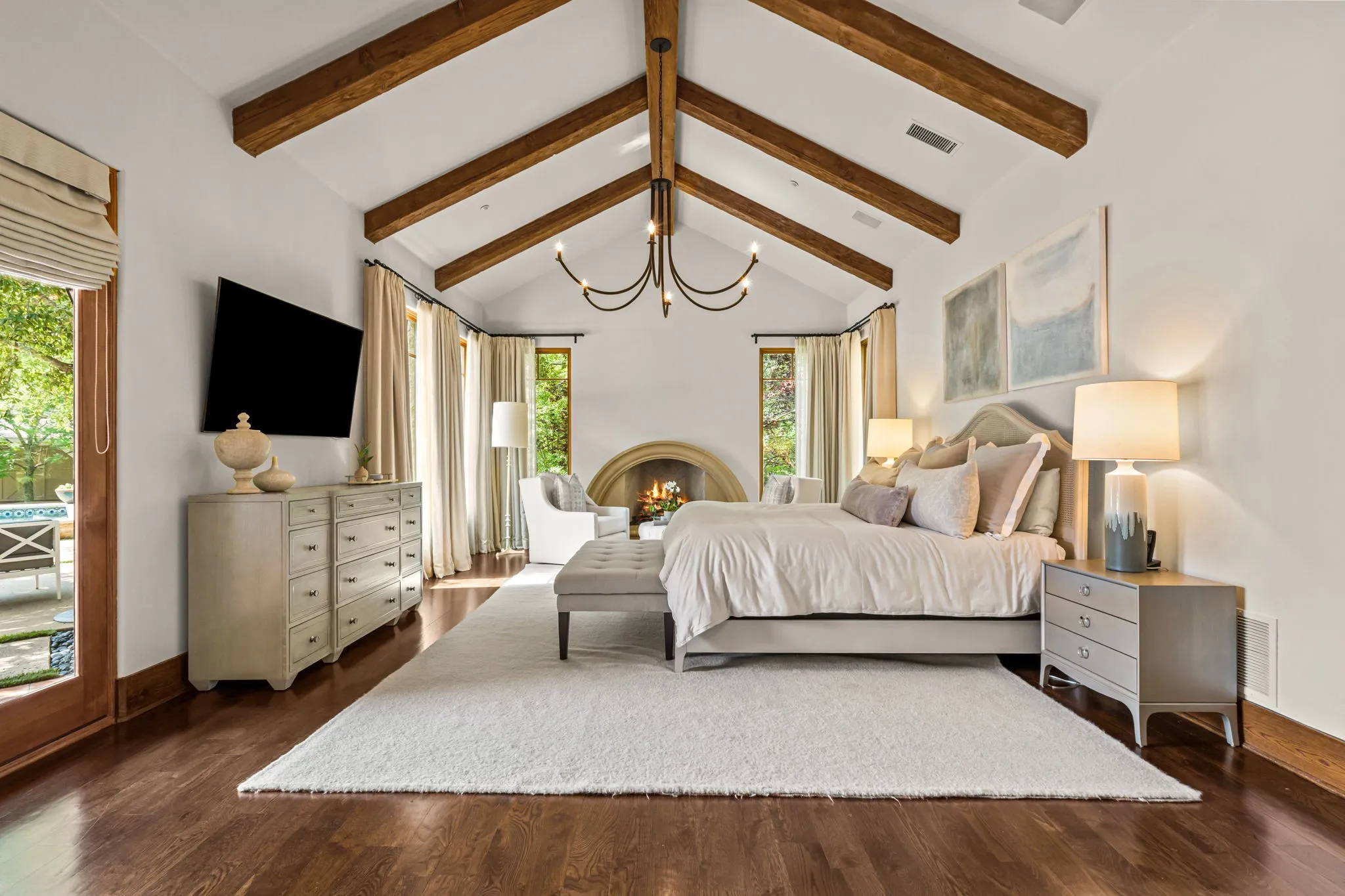It feels like you've entered a bedroom suite at a spa; warmth of the floors and beams, custom fireplace and natural light diffused by the trees outside.