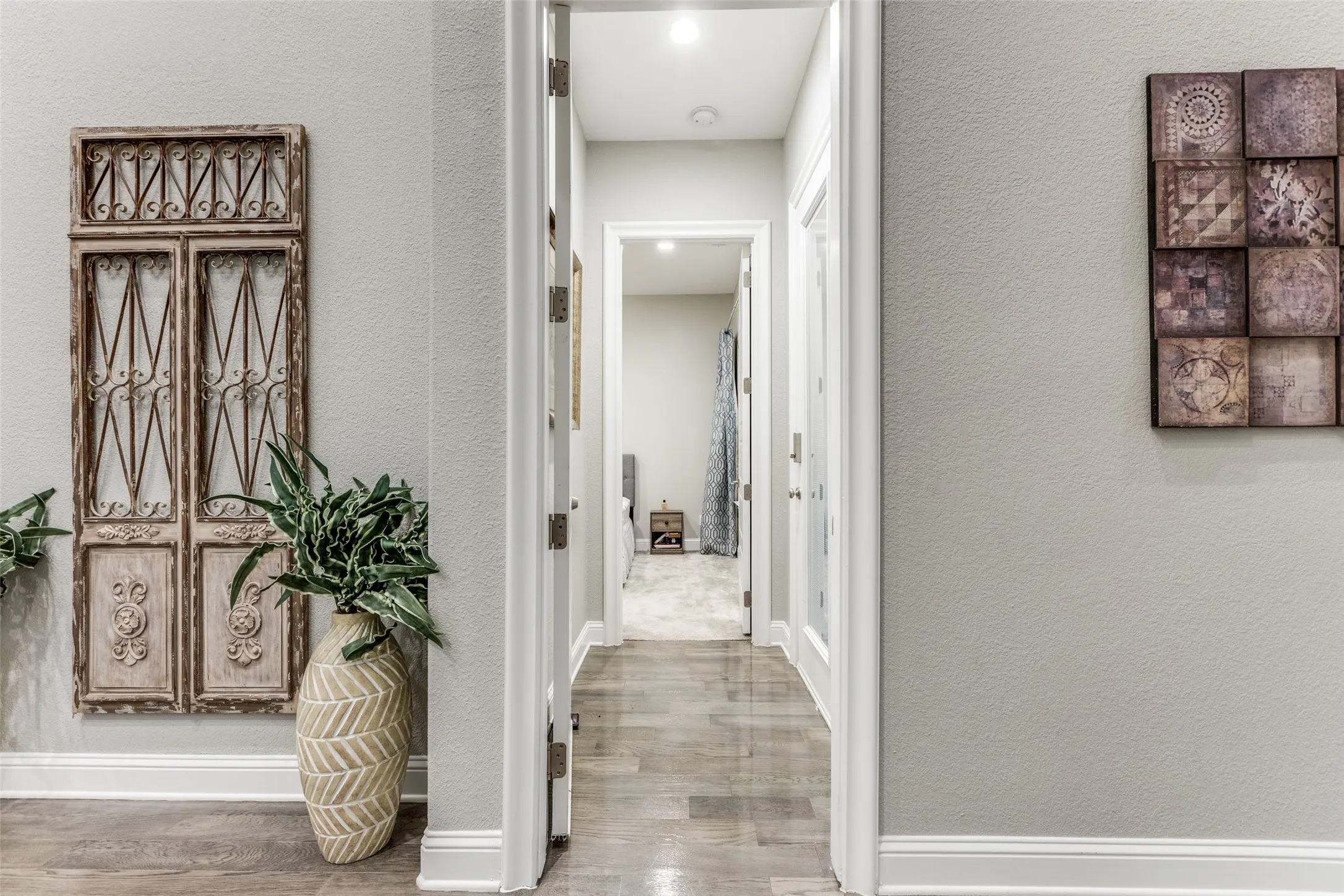 Hallway with wood-finish flooring and light gray painted walls
