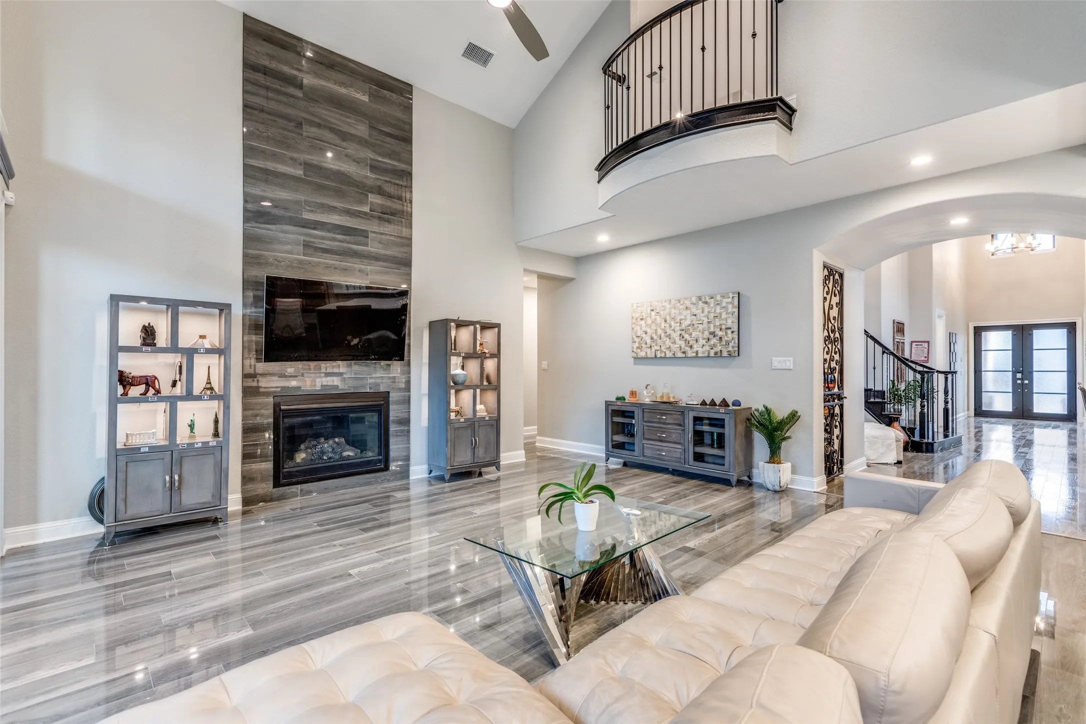 Two-story living area featuring a vaulted ceiling and contemporary wood-look tile flooring