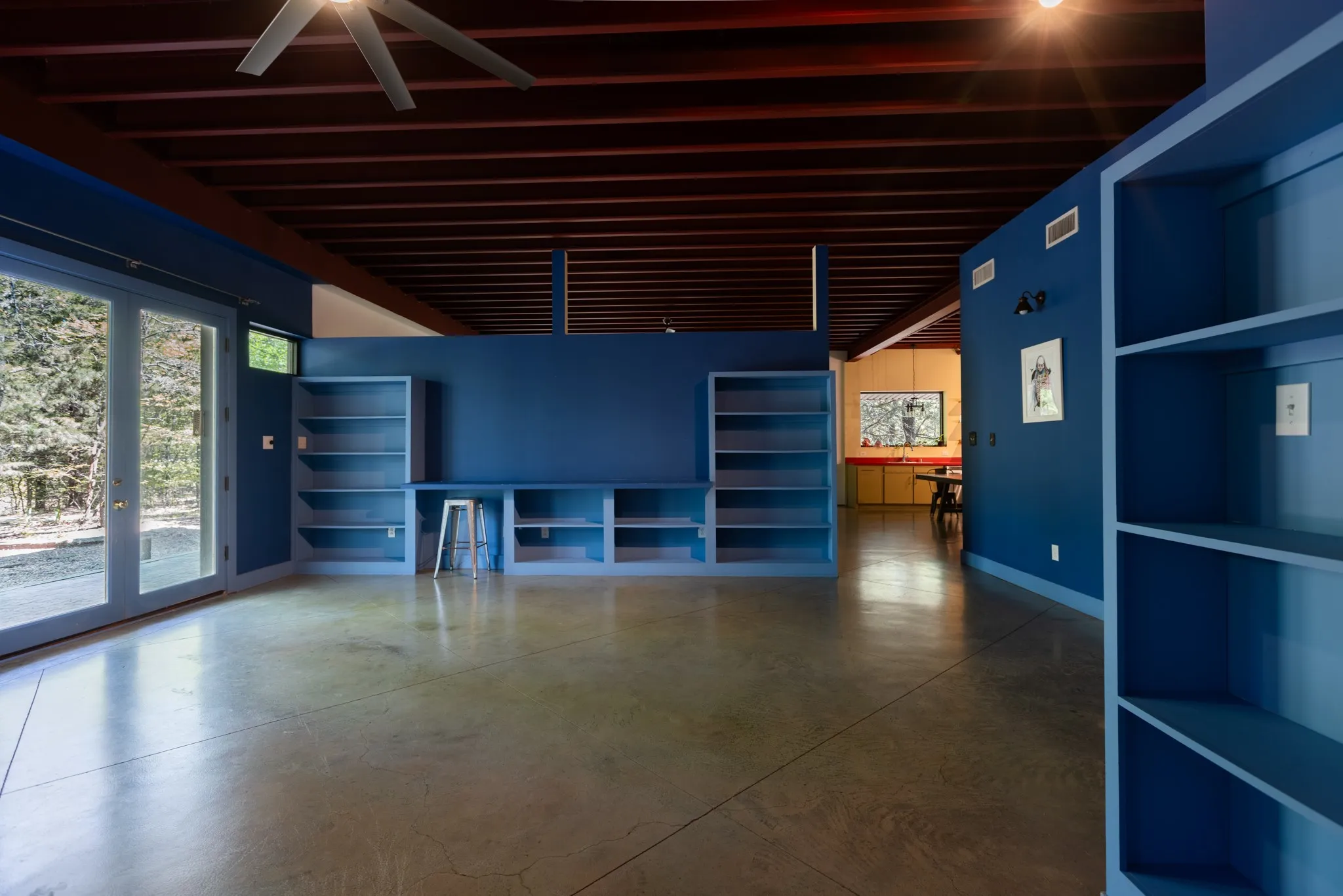Primary bedroom with built-in shelves and ceiling fan.