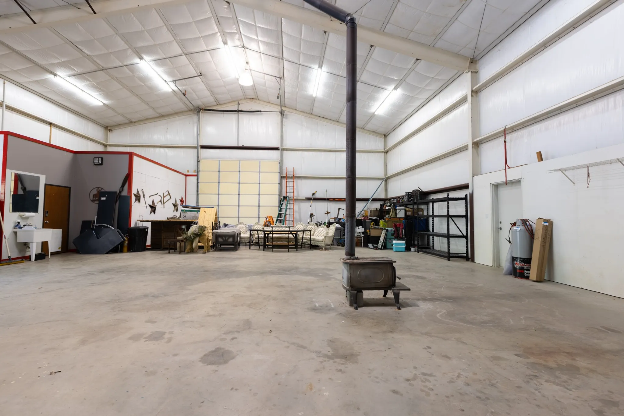 2500 sq ft workshop - garage.  Office in left corner with full bath.  Could be used as a bedroom. Wood burning stove.
