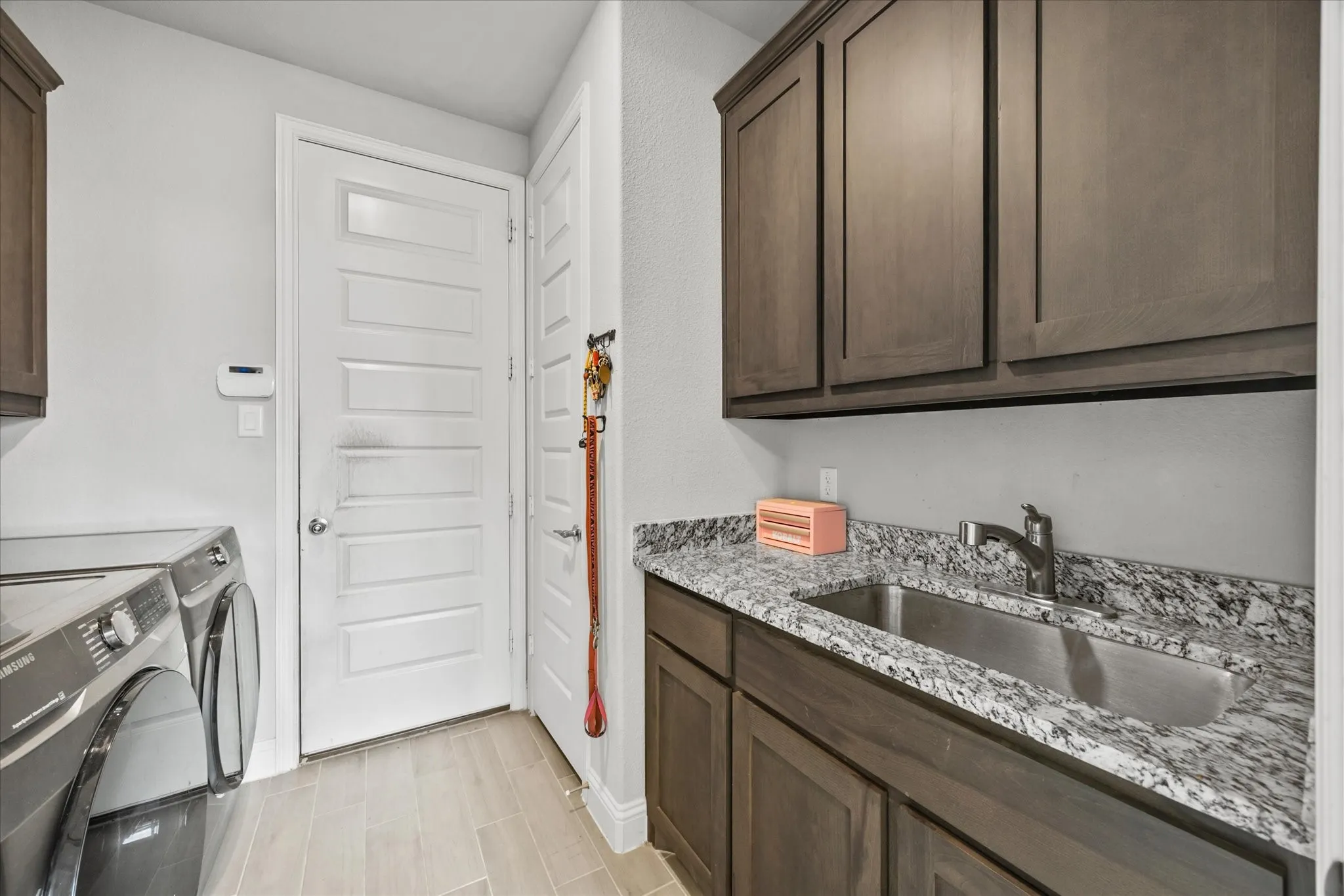 LARGE LAUNDRY ROOM WITH UTILTY SINK AND STORAGE