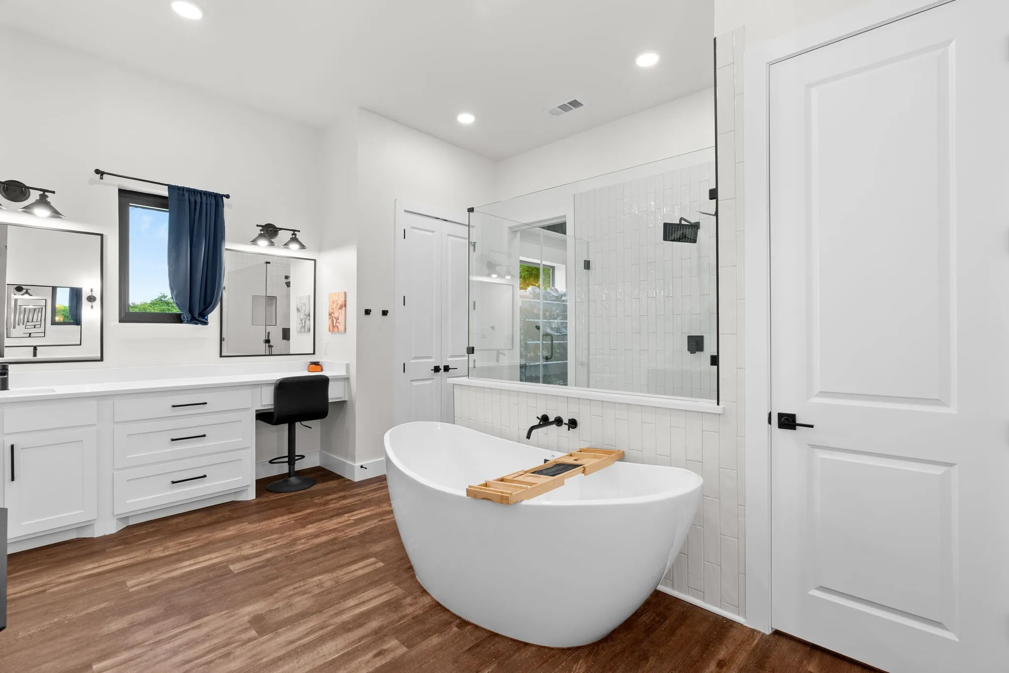 Bathroom featuring a freestanding soaking tub, a walk-in shower with glass enclosure, and a double vanity with ample counter space