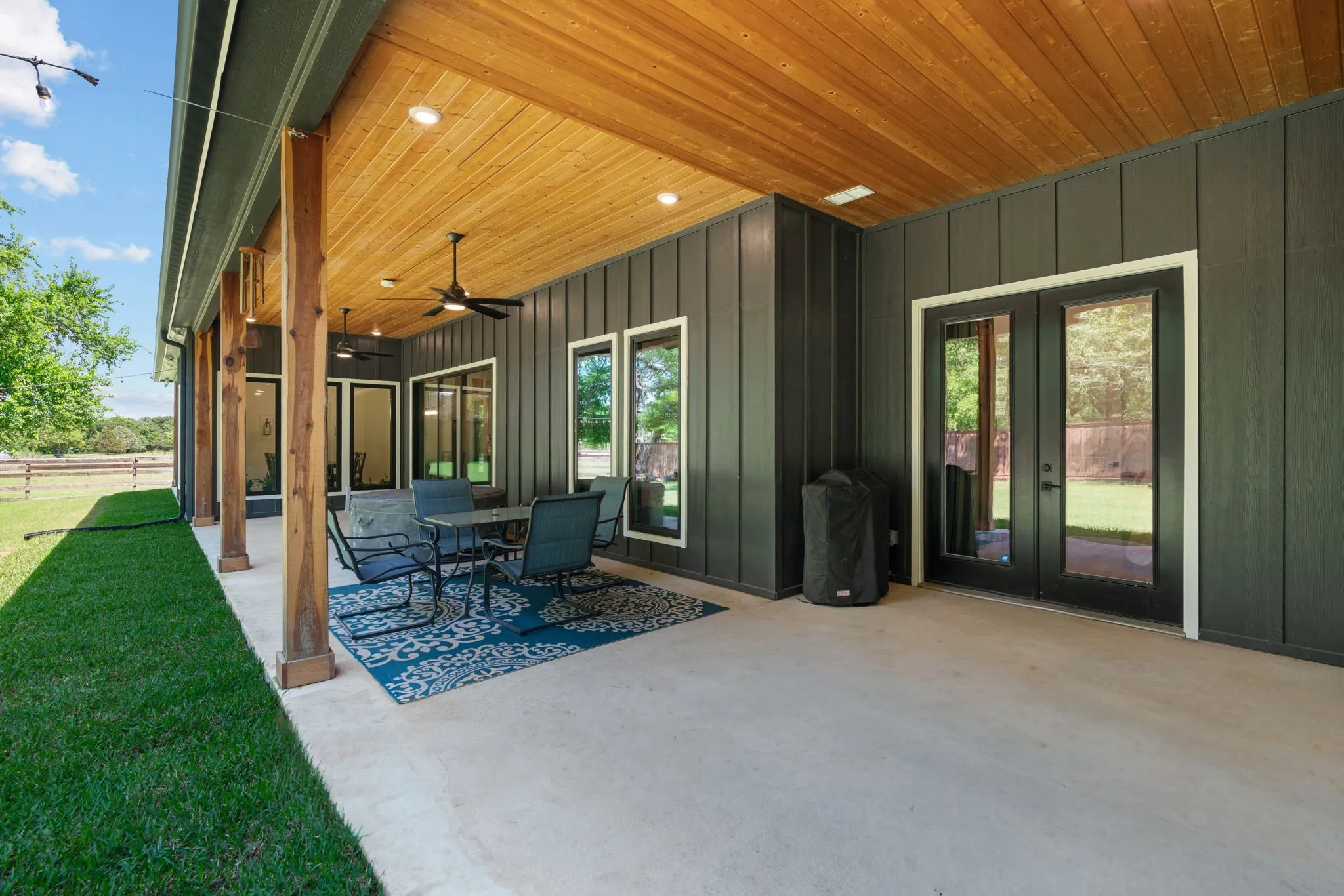 Expansive covered patio featuring a wood-finish ceiling, recessed lighting, and dual ceiling fans