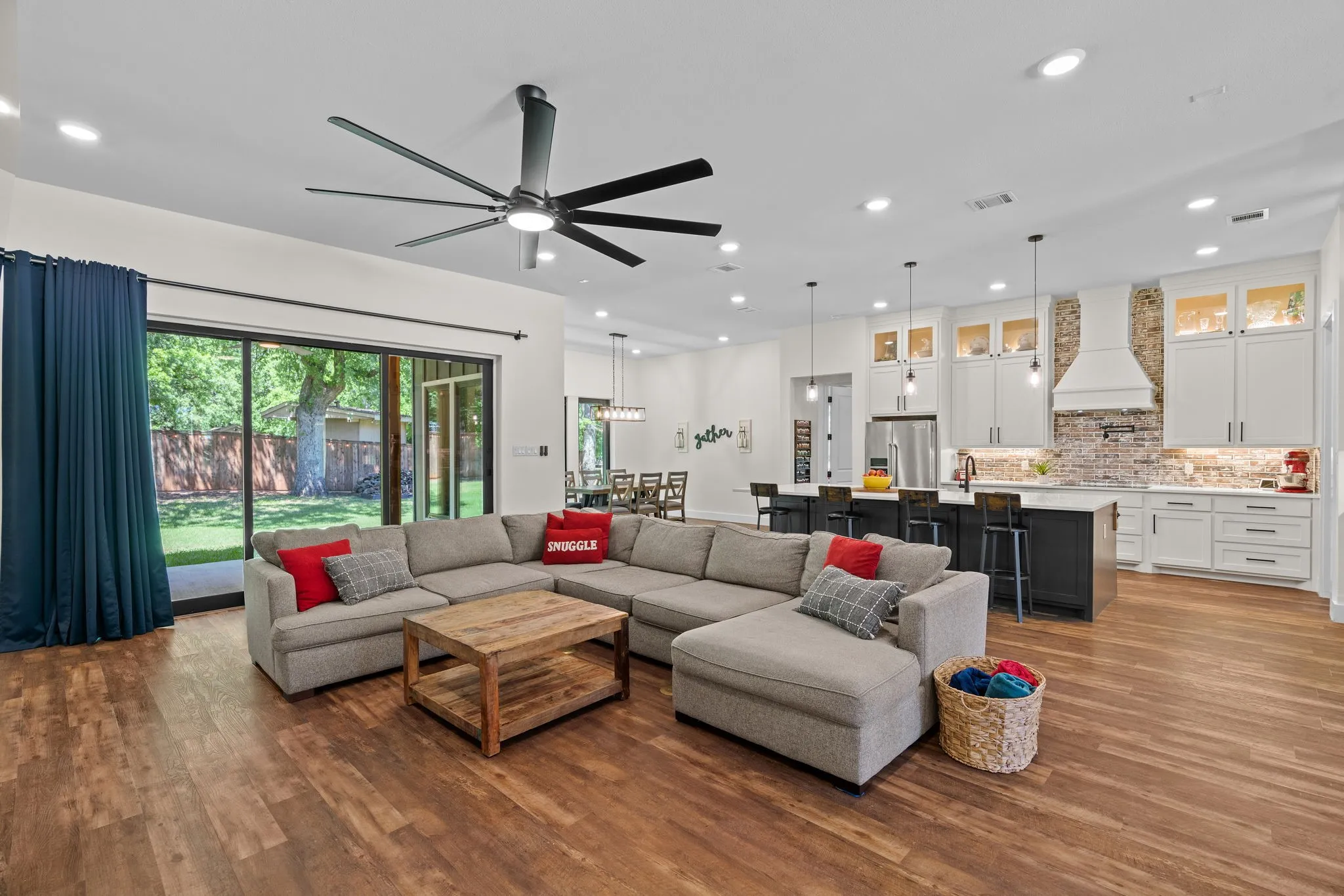 Open-concept living area featuring wood-finish flooring, recessed lighting, and a large ceiling fan
