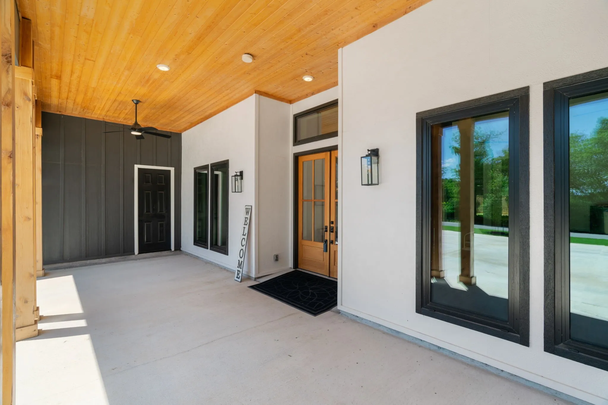 Covered front entry featuring a wood-finish ceiling, recessed lighting, and a modern ceiling fan