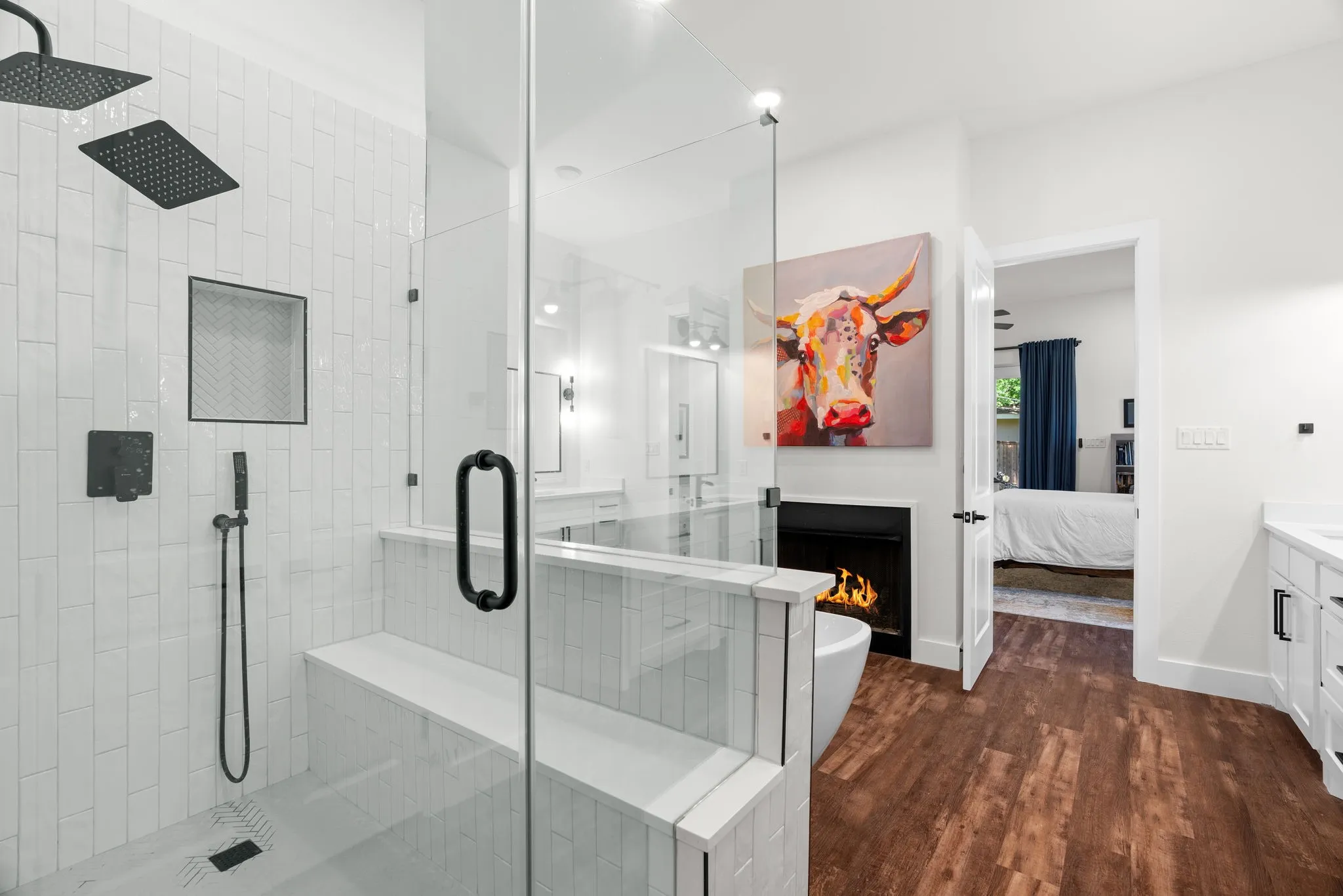 Spacious bathroom featuring a glass-enclosed shower with dual shower heads, a built-in shower bench, and a tiled accent niche