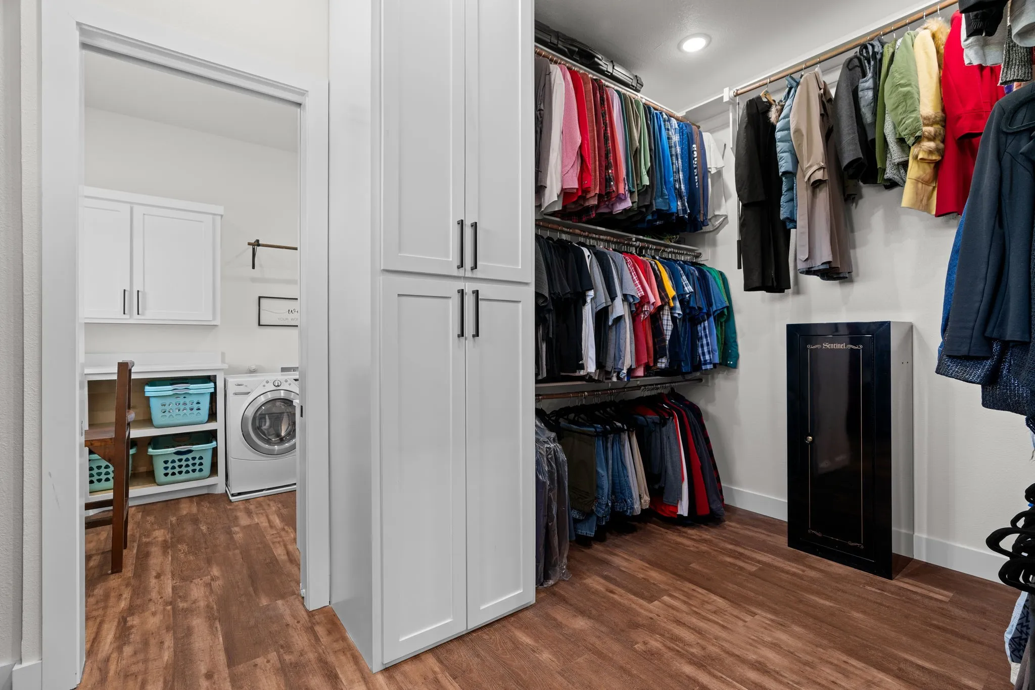 Custom closet system featuring wood-finish flooring, recessed lighting, and white baseboards
