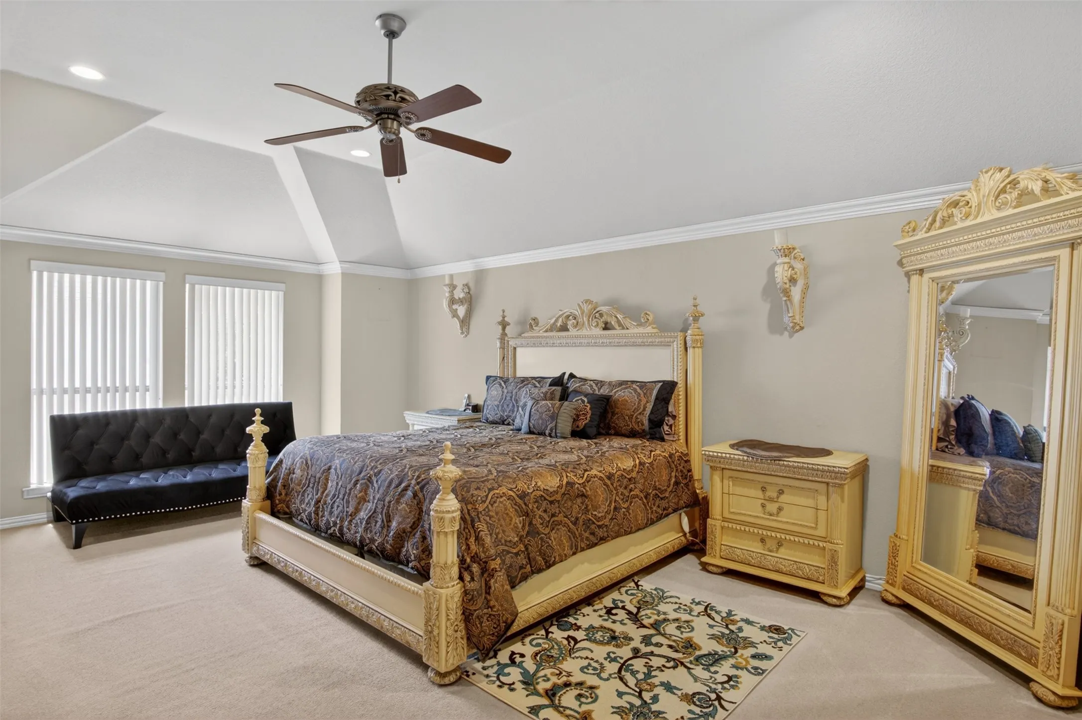 Spacious room featuring vaulted ceilings, a ceiling fan with integrated lighting, recessed lighting, and two tall windows with vertical blinds