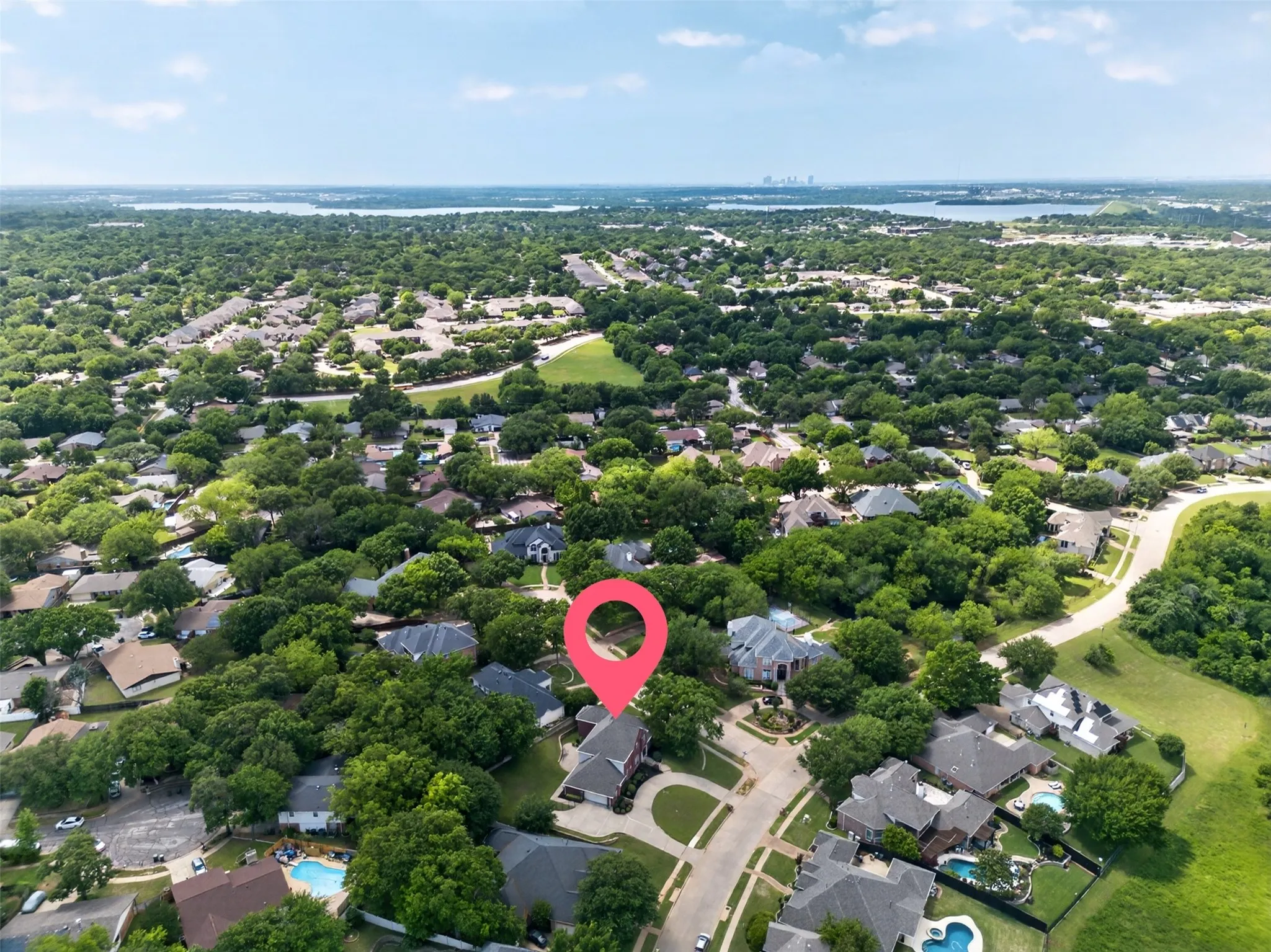 Aerial perspective showcasing a residential neighborhood with extensive tree canopies