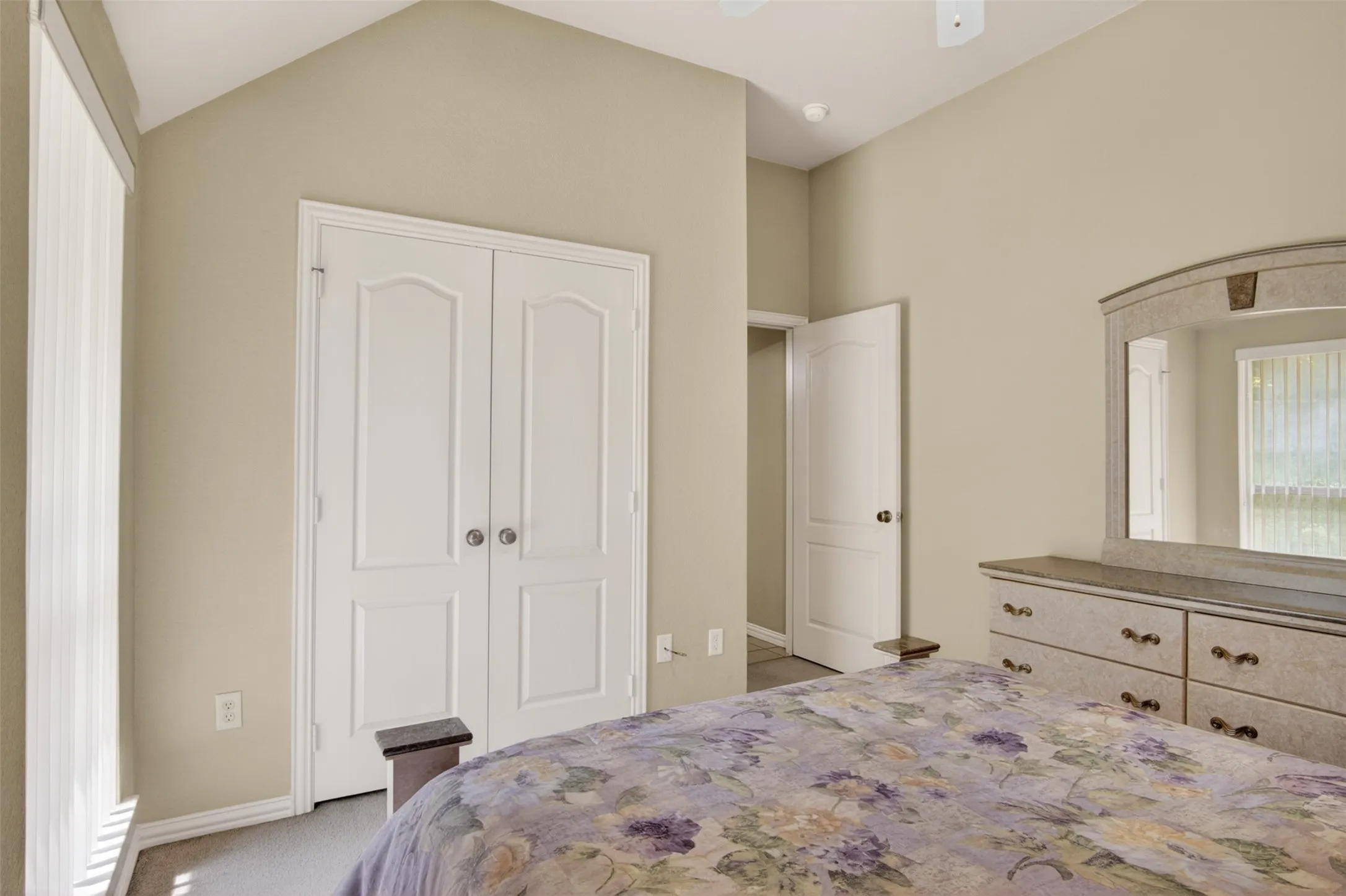 Vaulted ceiling room with neutral-toned walls