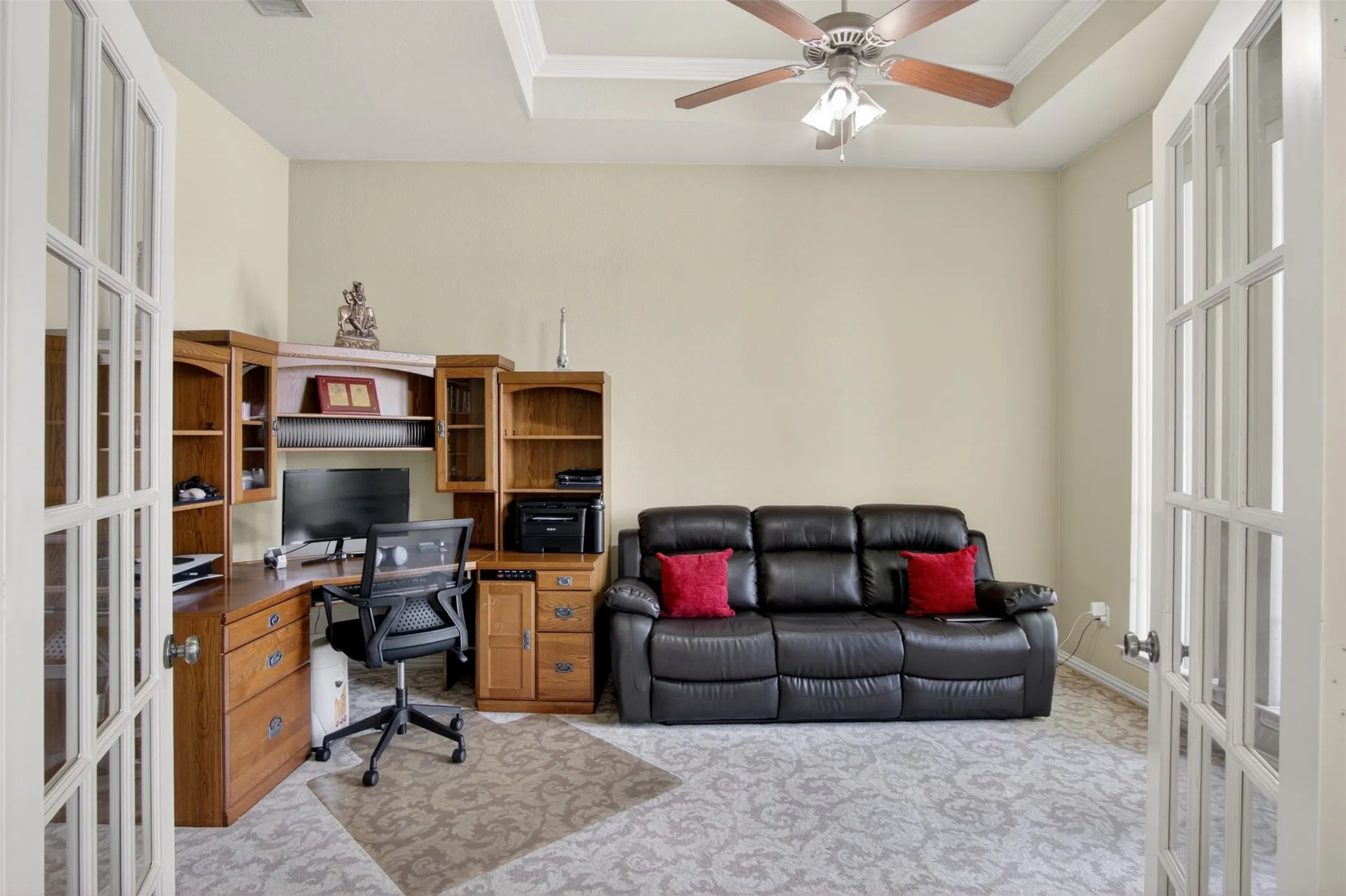 Room featuring a tray ceiling, ceiling fan with light, and light-colored walls
