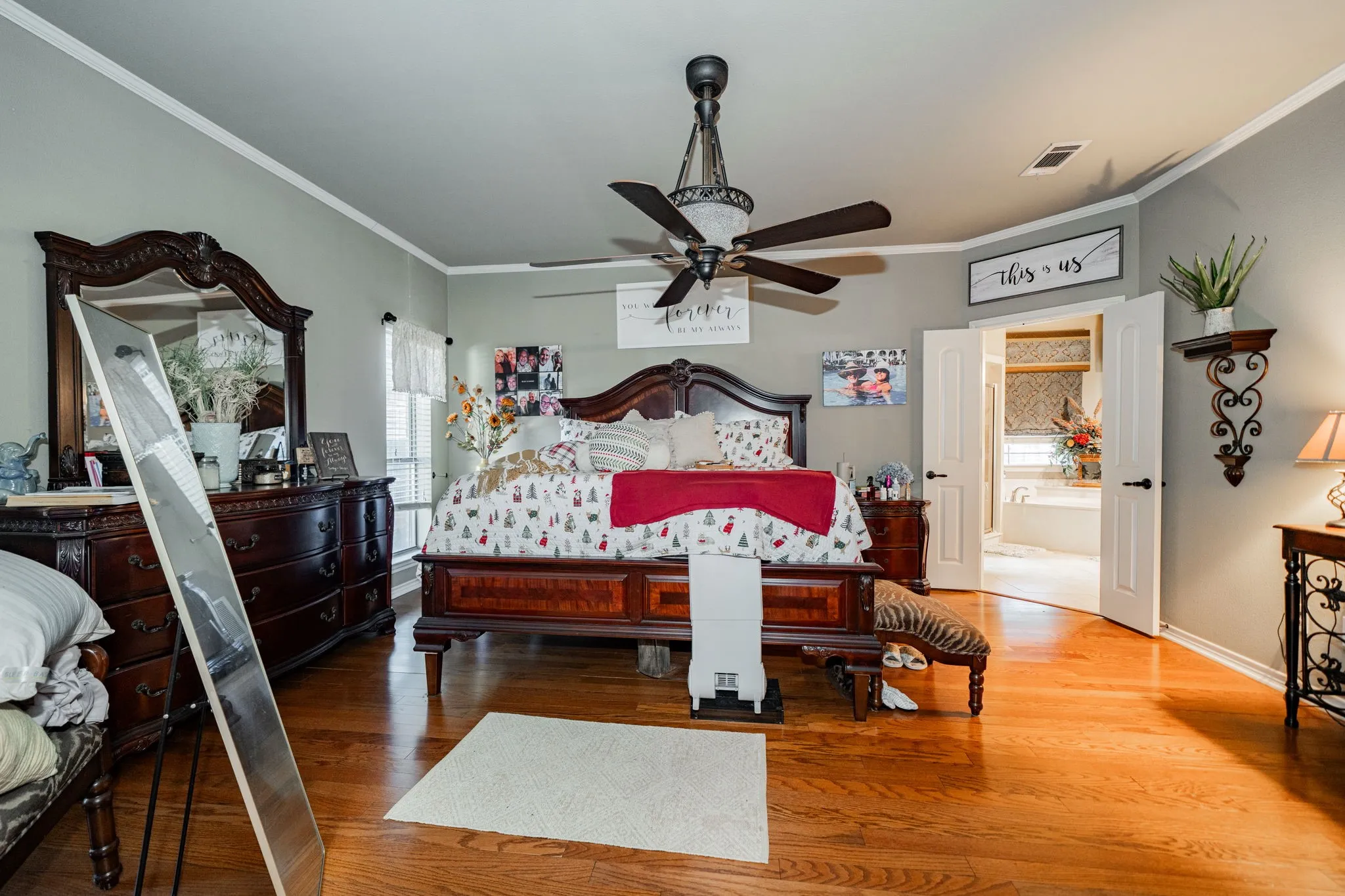 Spacious room featuring wood-finish flooring, light gray walls, and white crown molding