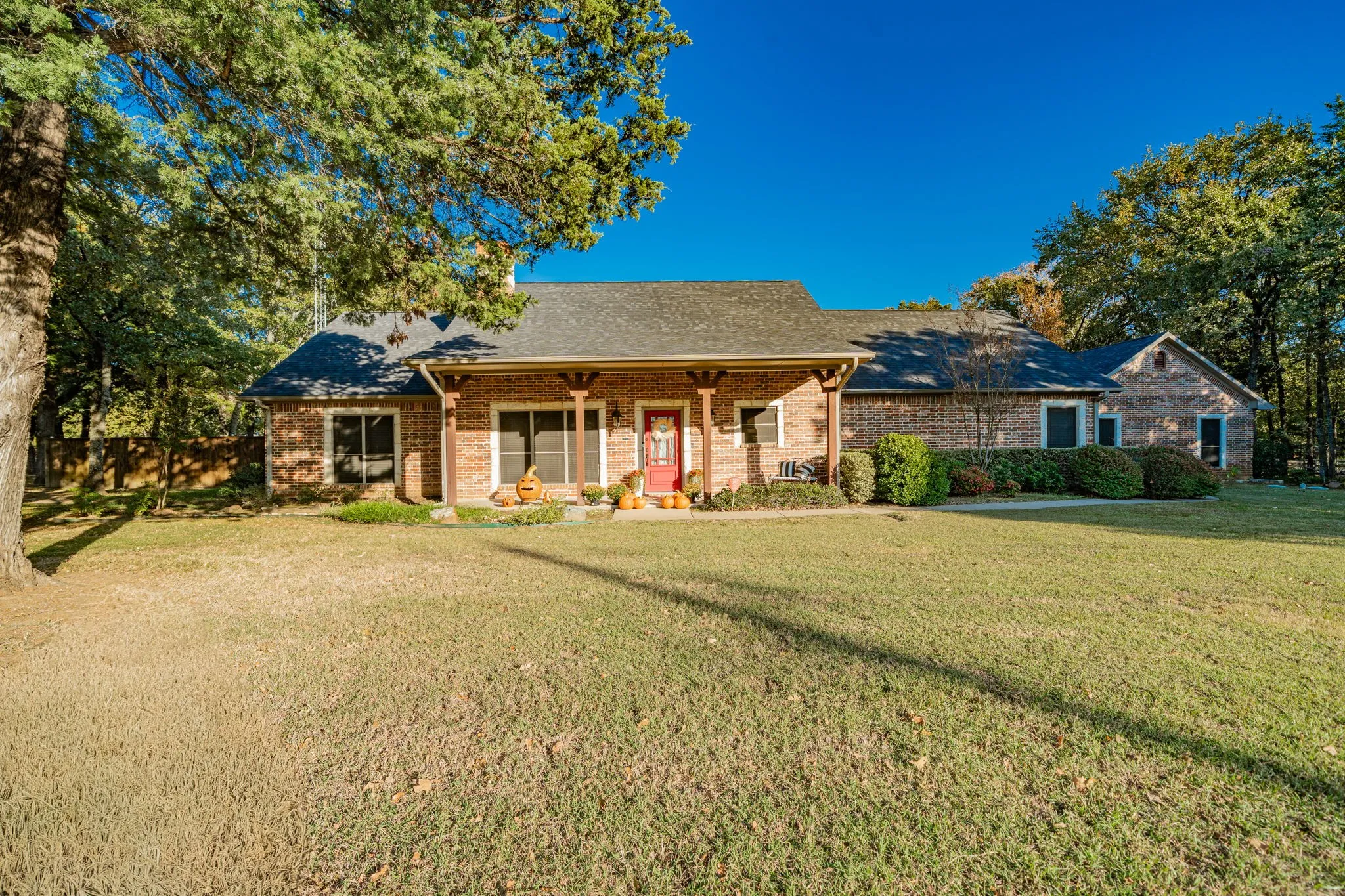 Brick exterior architecture with a covered front porch featuring wood support columns