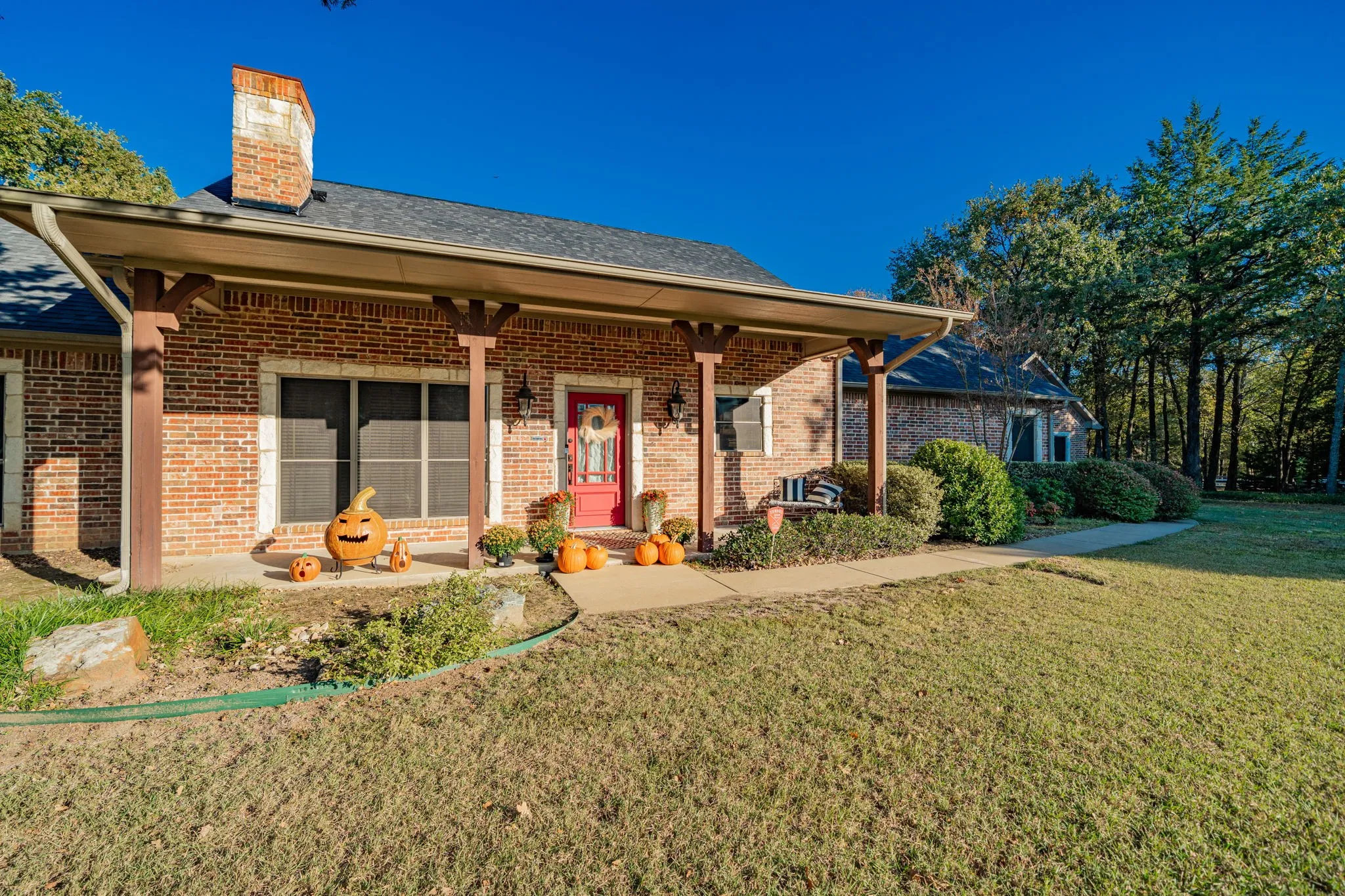 Brick exterior featuring a covered porch with exposed wood columns