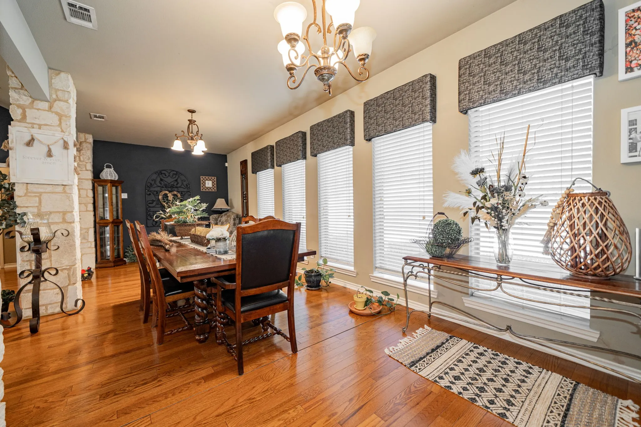 Dining area featuring wood-finish flooring and a stone-clad architectural column