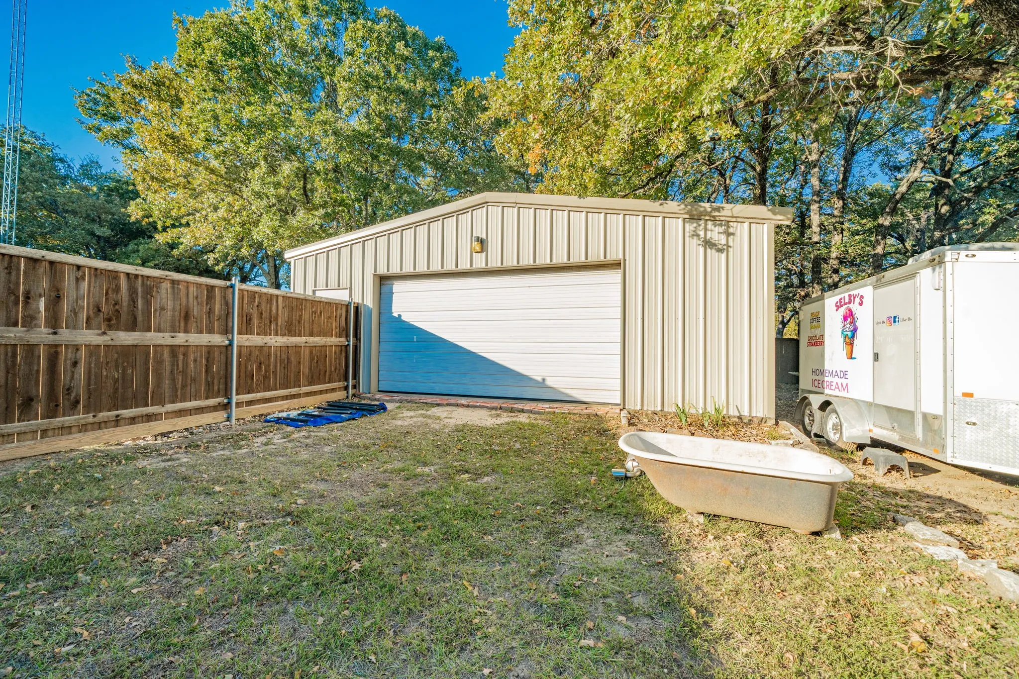 Metal utility building with electricity, concrete floor, and a roll-up garage door and an additional entry door