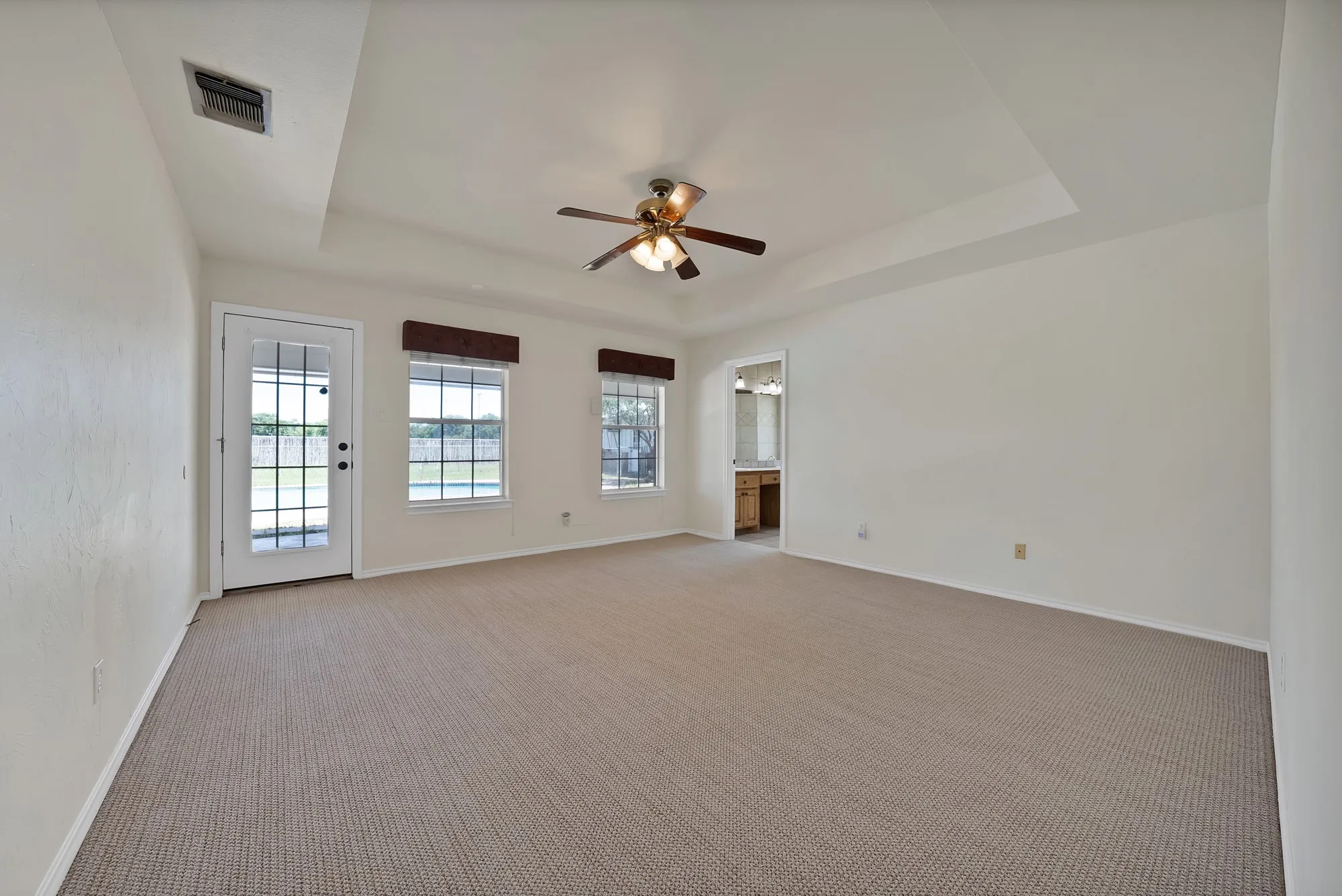 Primary bedroom with view of pool and access to back porch