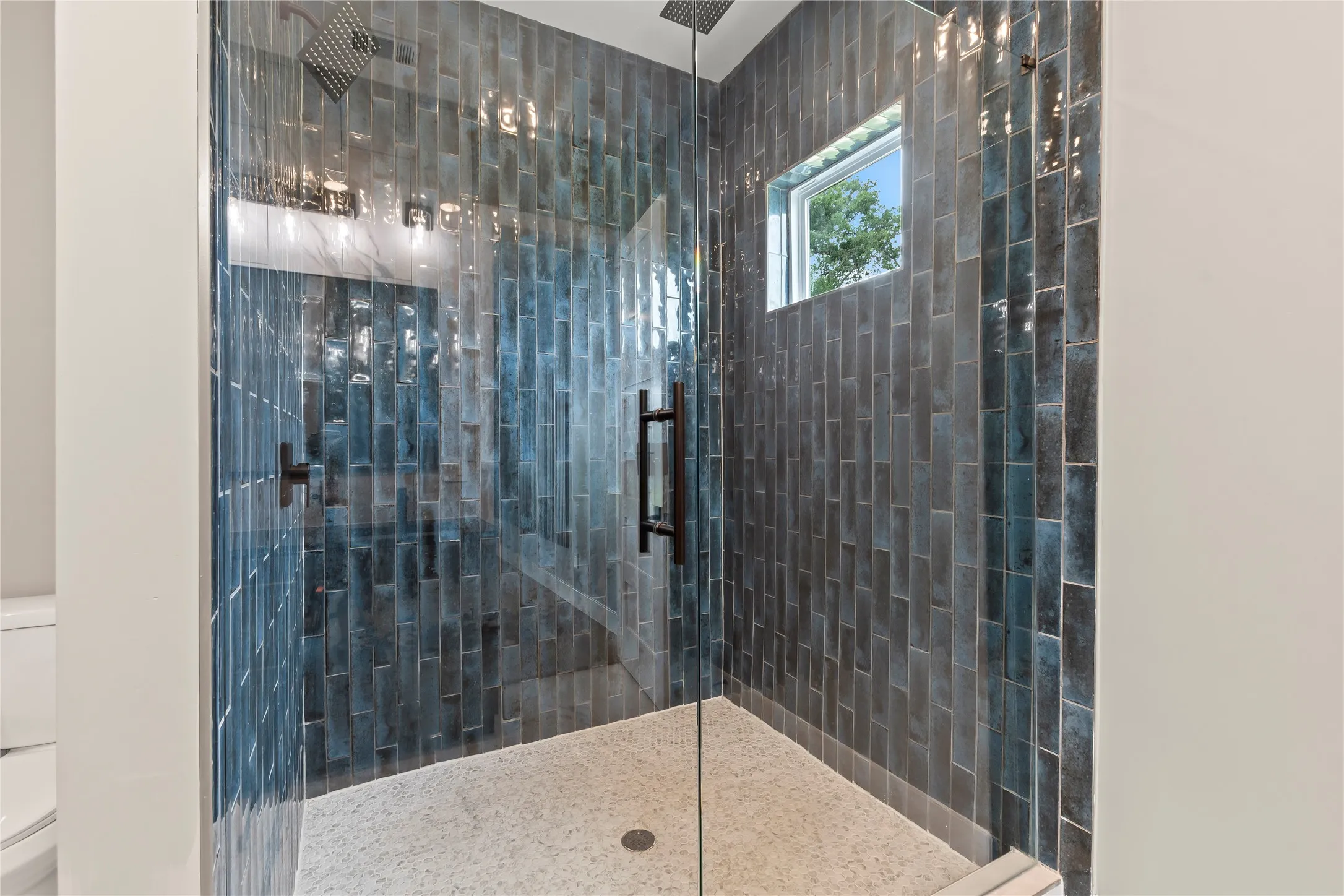 Frameless shower surrounds with spacious walk-in tile shower.