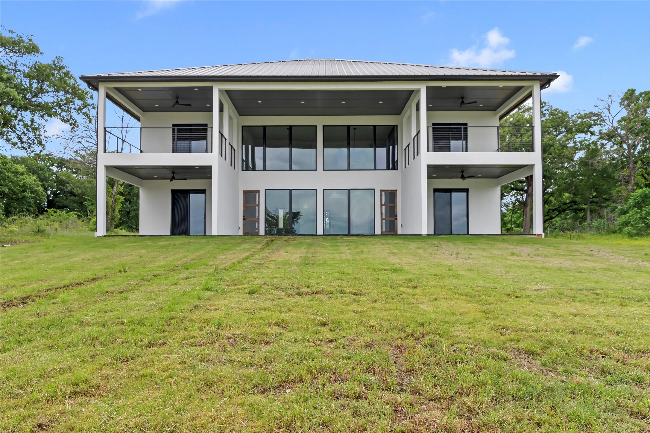 Waterside View of Home showing all four private outdoor spaces plus the main patio off the living space.
