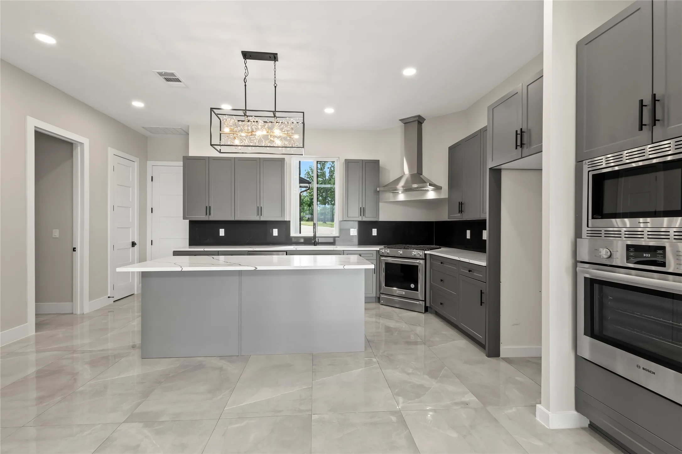 A chef-inspired kitchen featuring a large gathering island, double ovens, 5-burner gas range, and oversized walk-in pantry.