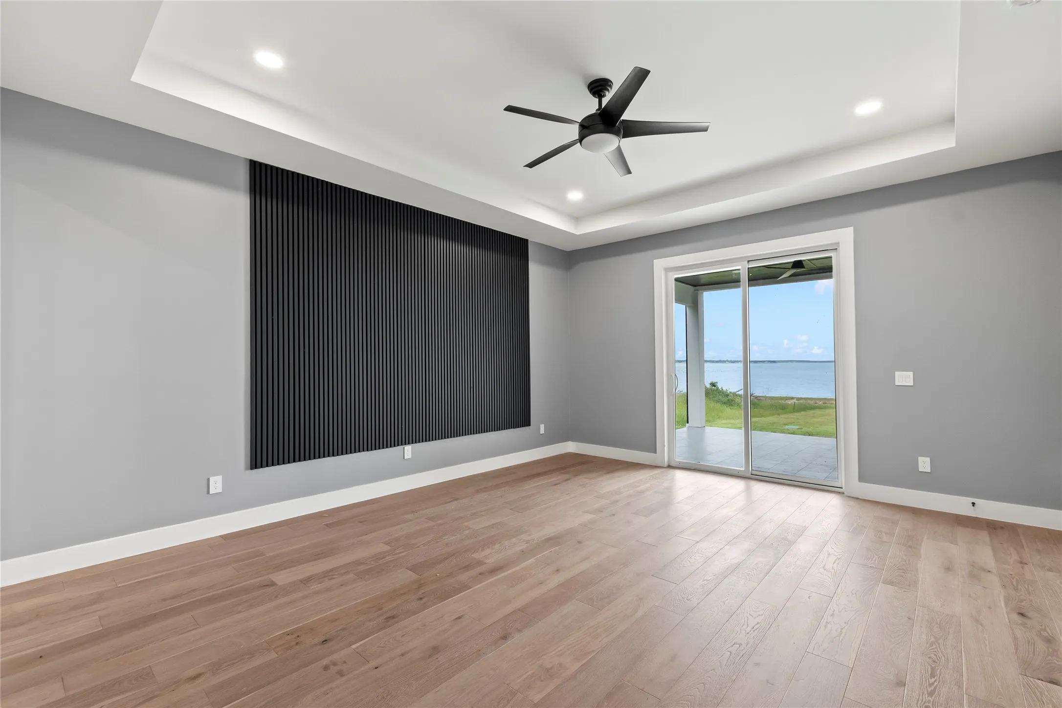 Primary Suite One - Downstairs - Wake up to open water views from private bedroom retreats with private patio access, wood floors, trace ceilings, large glass doors.
