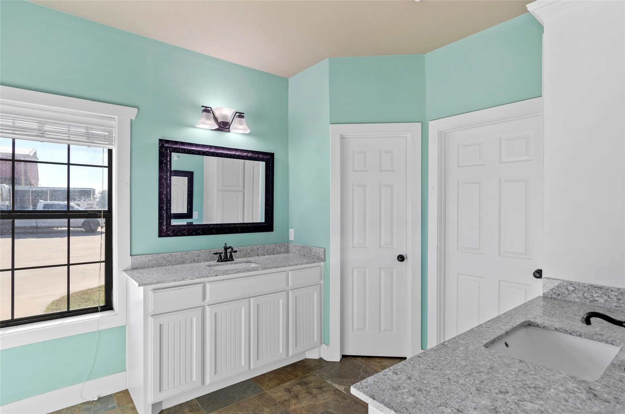 Bathroom featuring two vanities and stone finish floors