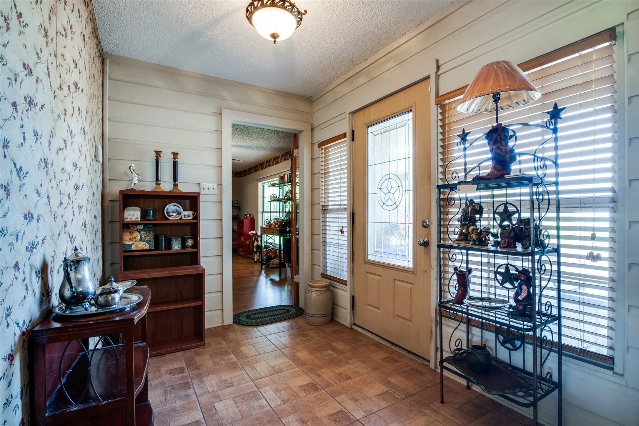 Entryway featuring tile flooring, a decorative glass-paneled entry door, and horizontal paneling