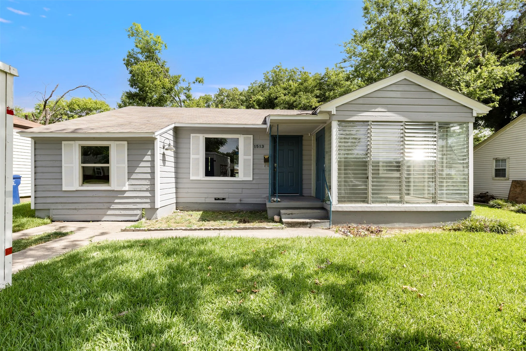 Light gray siding exterior with white window shutters