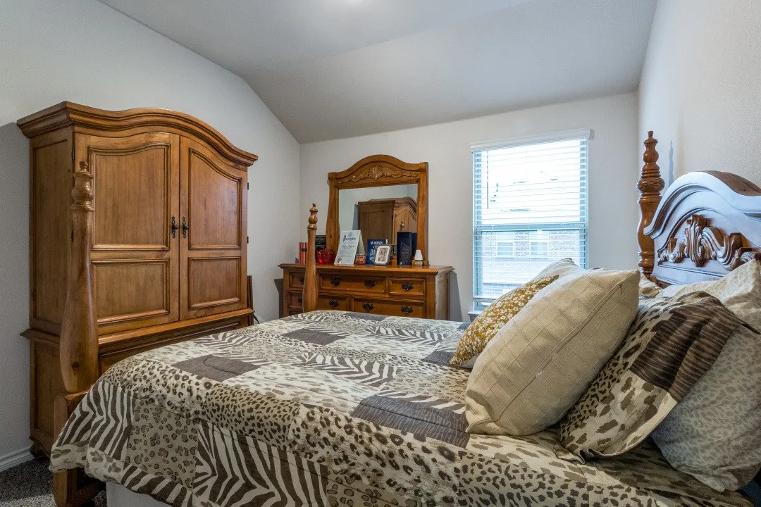 Bedroom featuring light-colored walls, carpeted flooring, and a window with blinds
