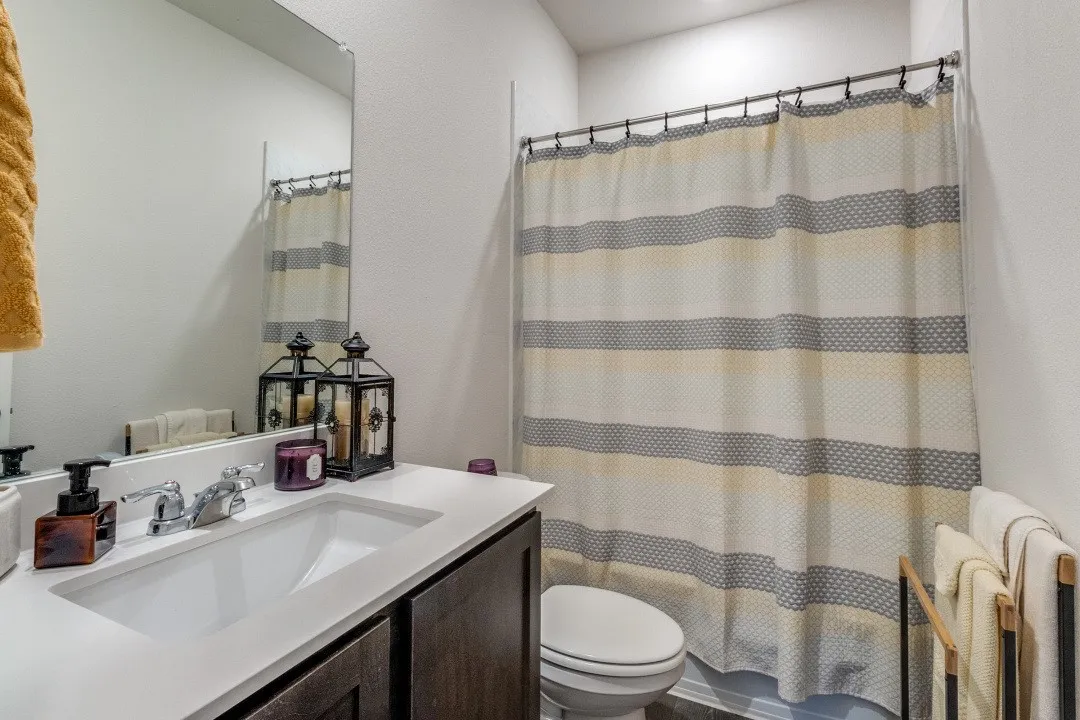 Vanity with an integrated rectangular sink, chrome faucet, and expansive mirror