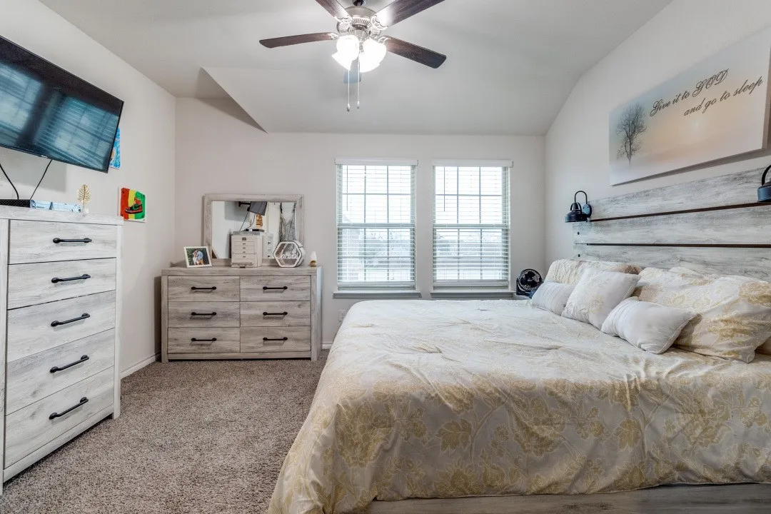 Carpeted interior space featuring a vaulted ceiling and a ceiling fan with integrated lighting