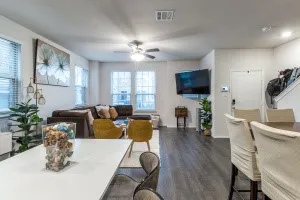Open-concept living space featuring wood-finish flooring, recessed lighting, and multiple windows with blinds
