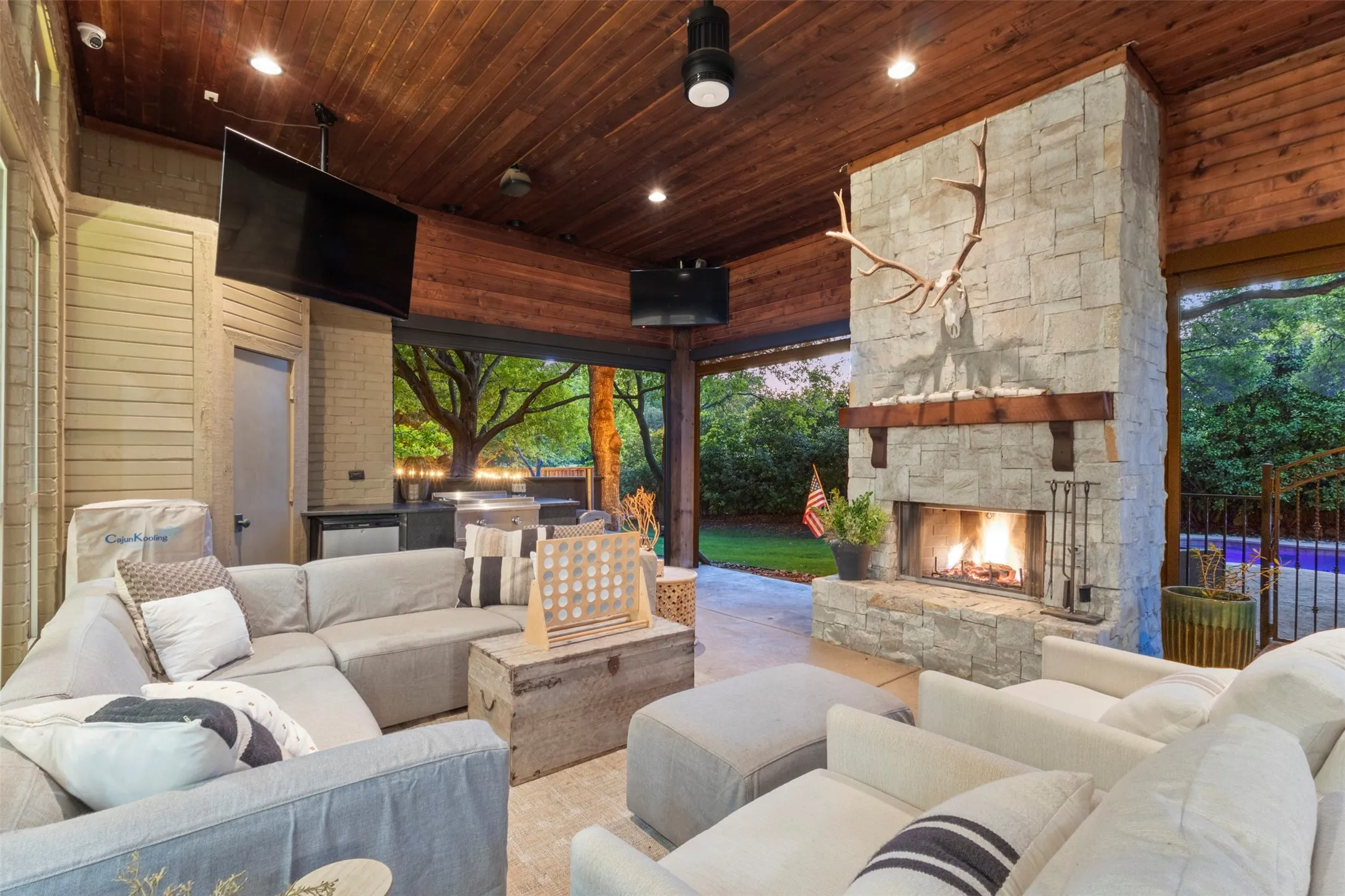 outdoor living w massive stone fireplace and wood ceiling