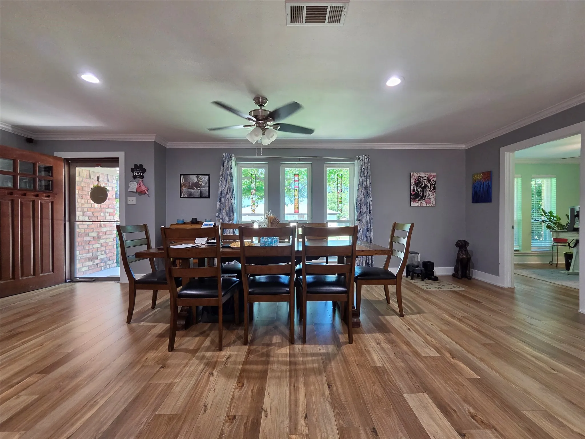 Spacious room featuring wood-finish flooring, crown molding, and recessed lighting