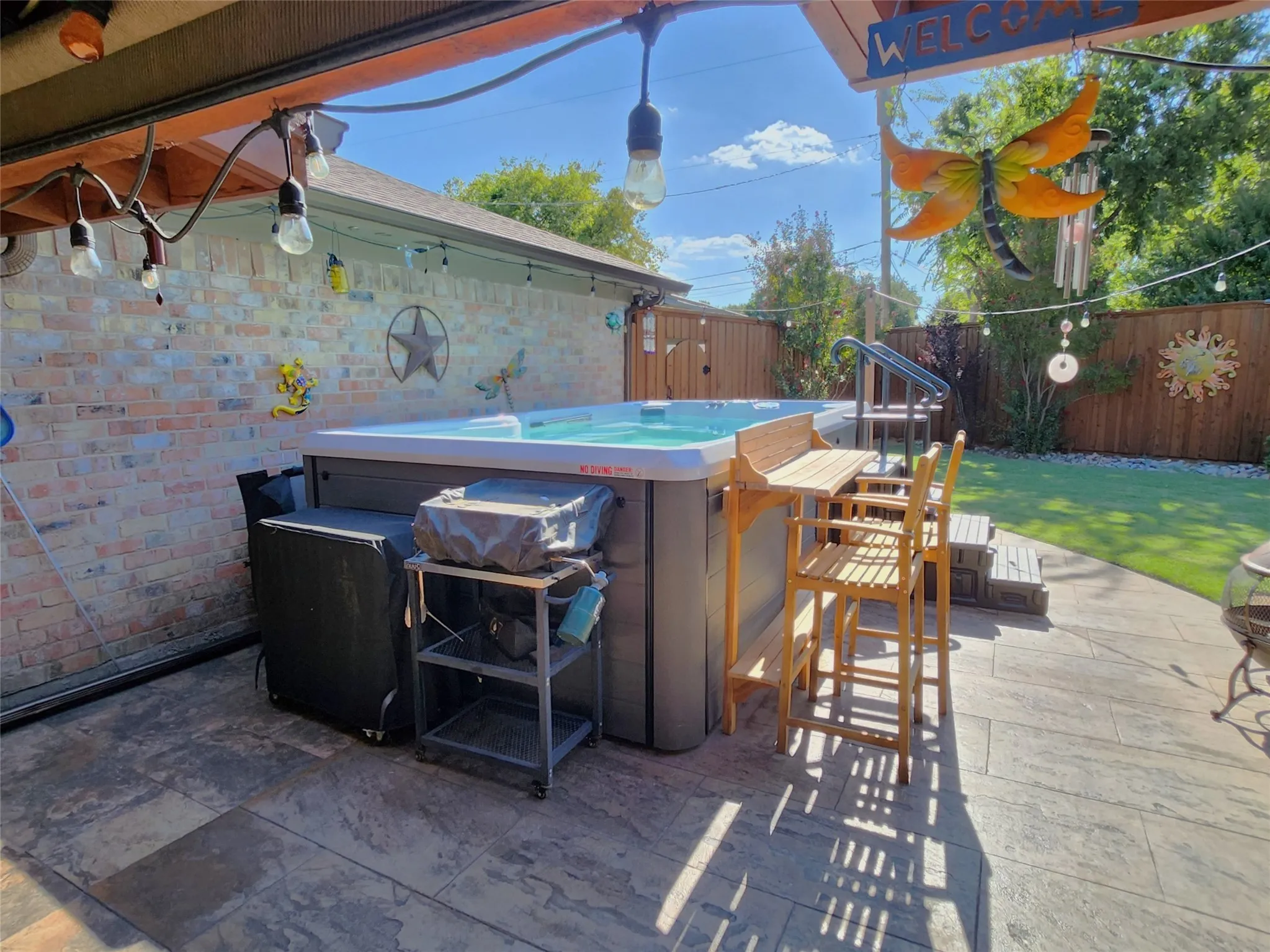 Patio space featuring a built-in hot tub with wood-finish steps and an attached bar