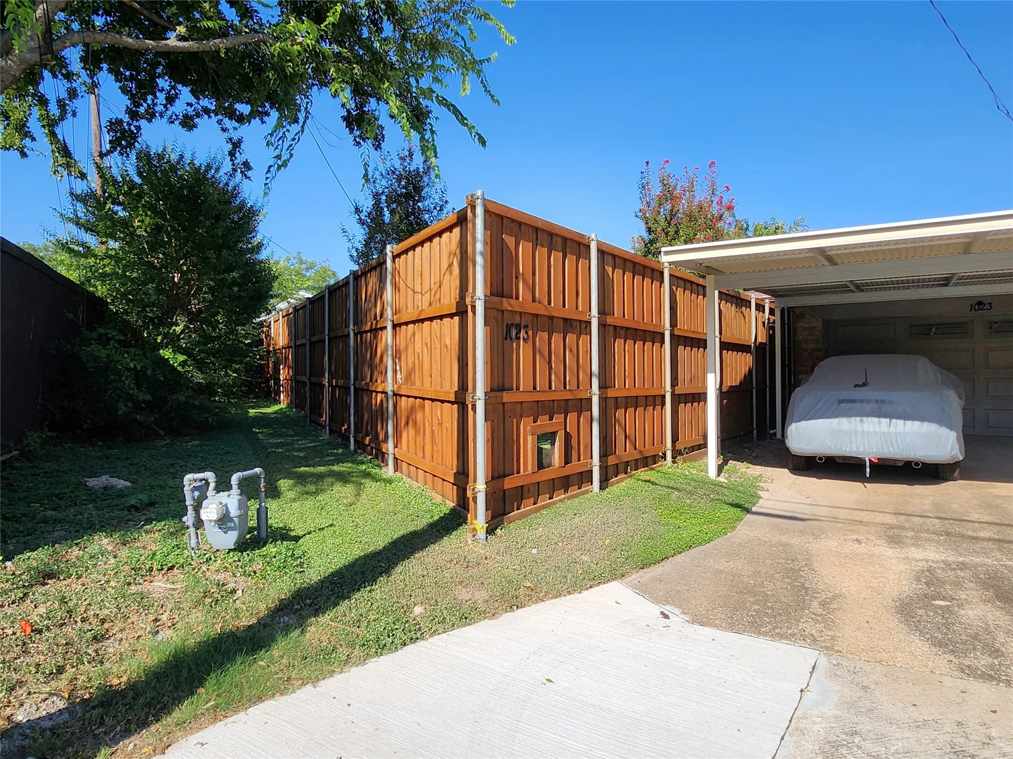Wood-plank privacy fencing bordering a grassed side yard