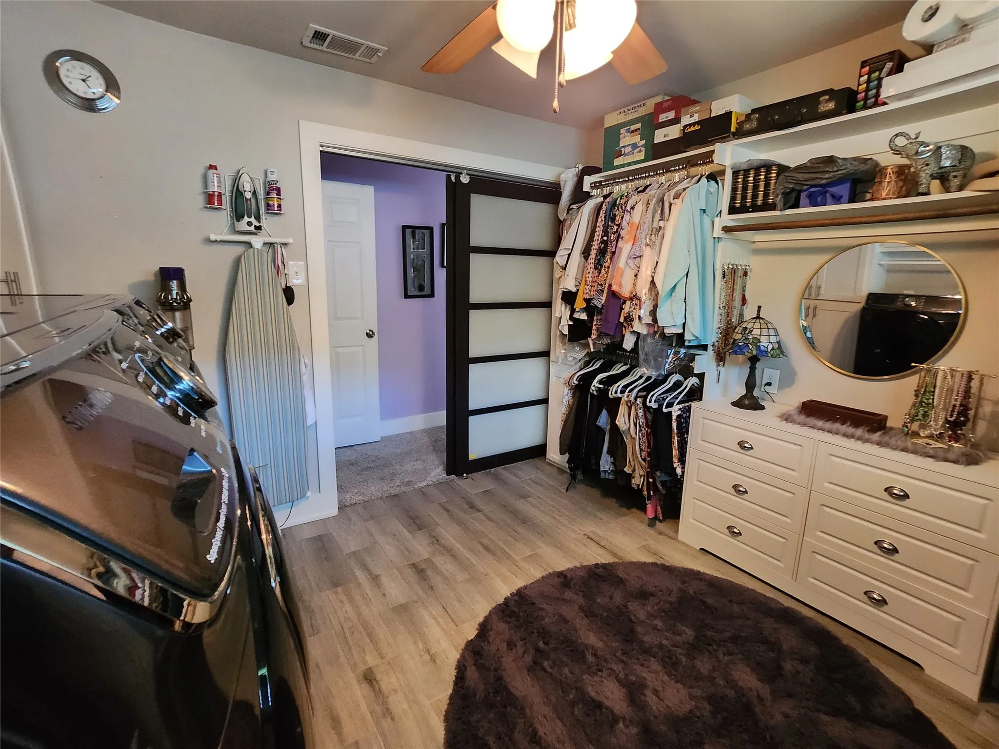 Dedicated laundry space featuring wood-finish flooring and a ceiling fan