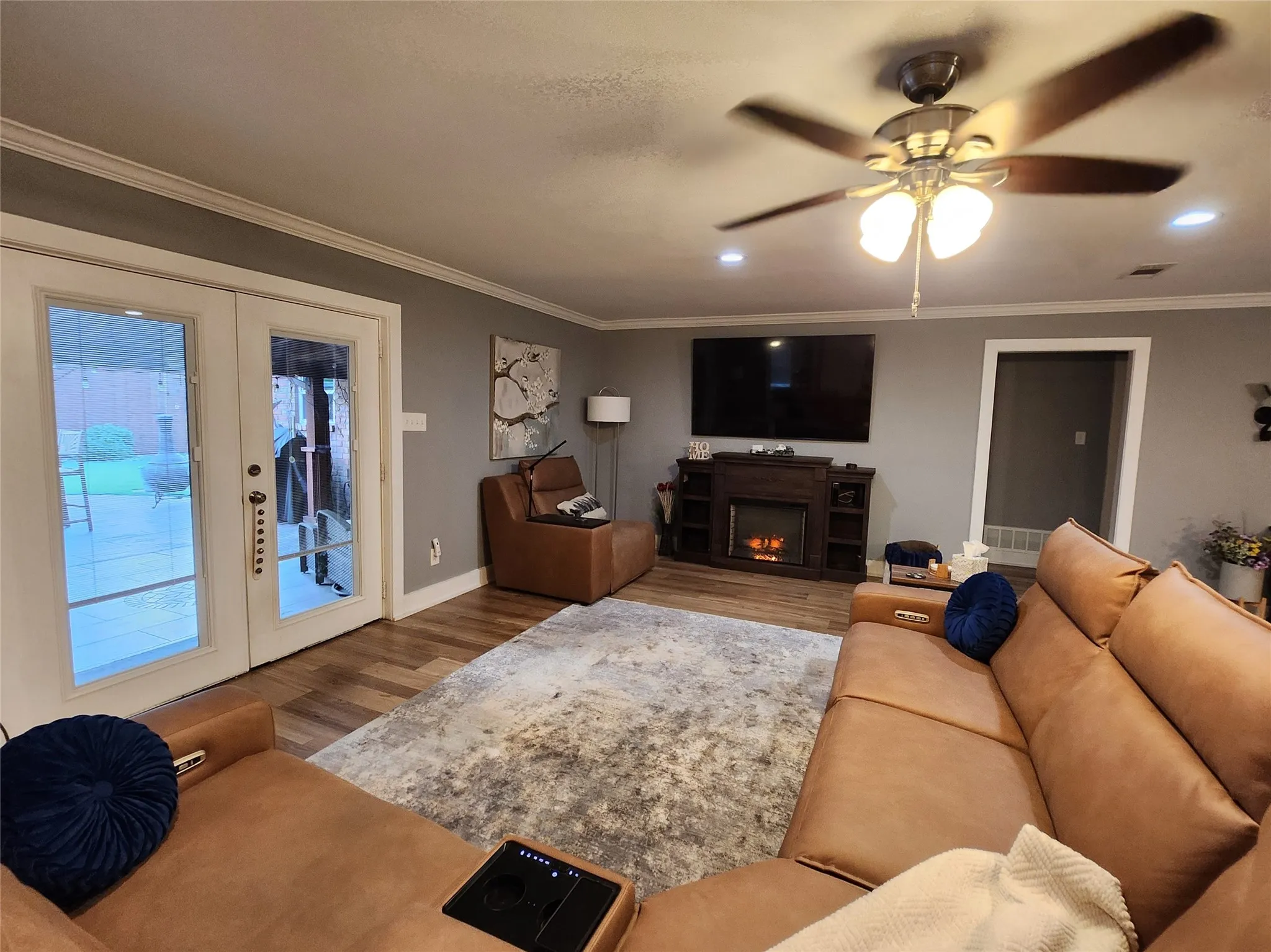 Living area featuring wood-finish flooring, recessed lighting, and a ceiling fan with integrated light