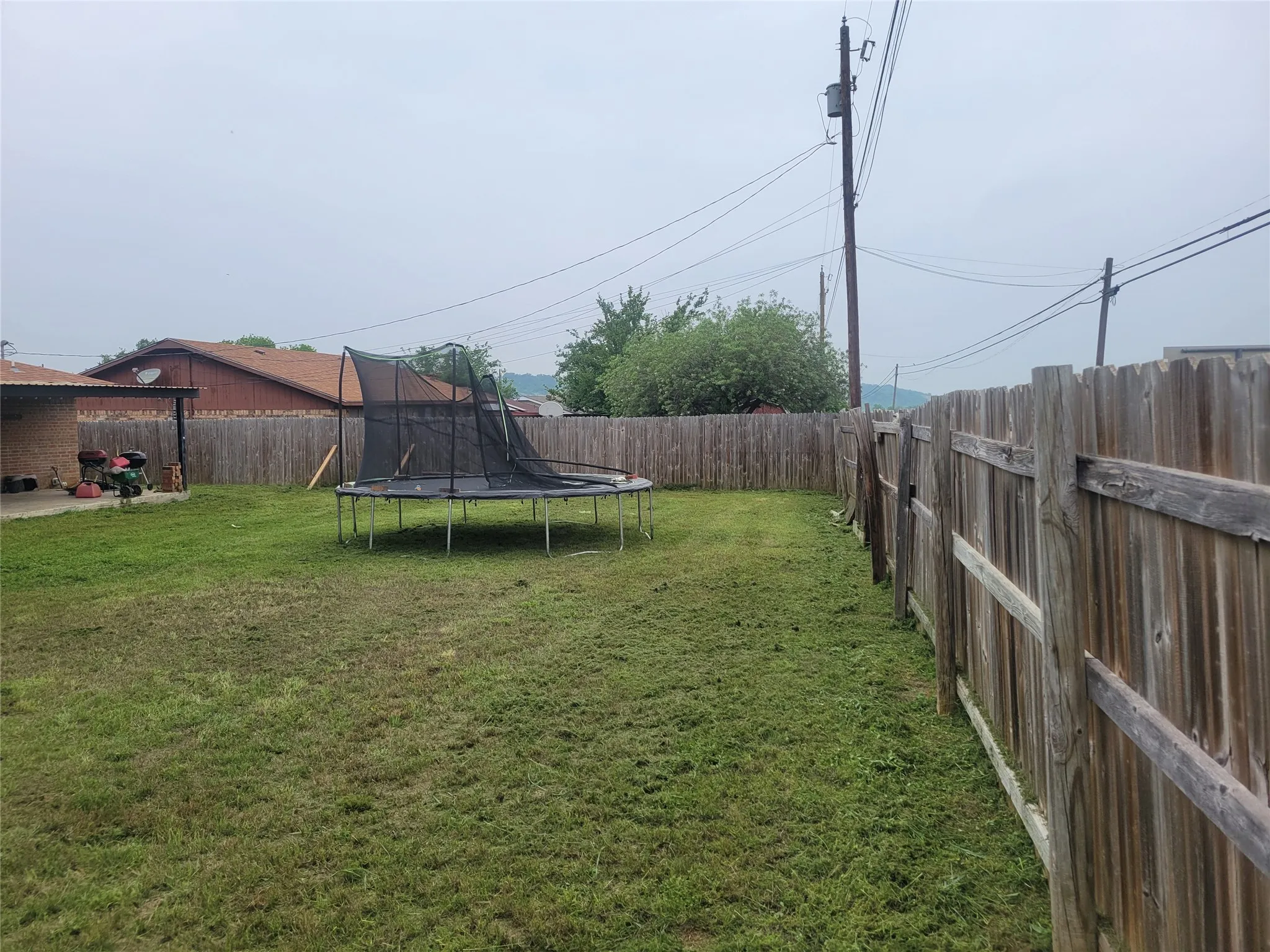 Expansive backyard featuring a privacy fence and a concrete patio area