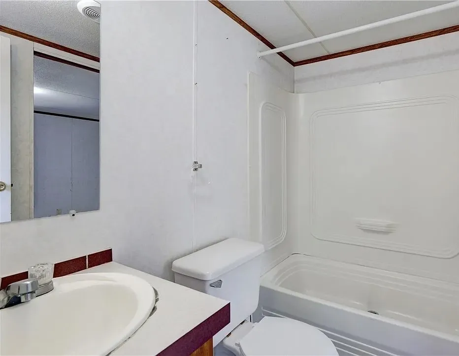 White acrylic tub and shower combination with a single-handle chrome faucet