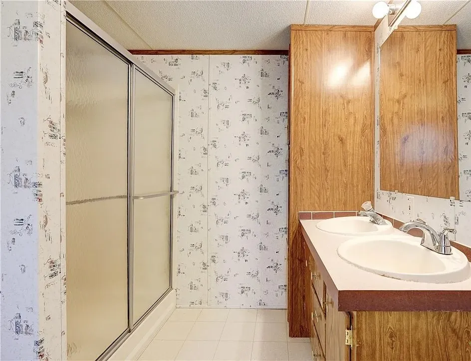 Double vanity with integrated sinks, chrome faucets, and an expansive mirror