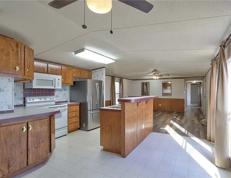 Kitchen featuring wood-finish cabinetry, tile flooring, and a stainless steel refrigerator