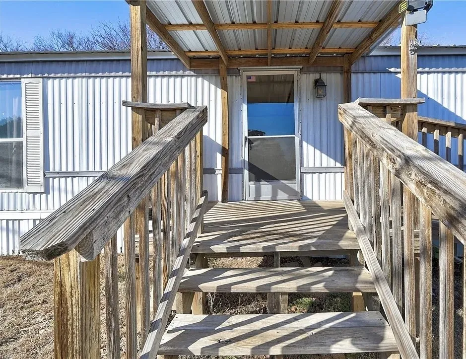 Covered porch with wooden railings and steps