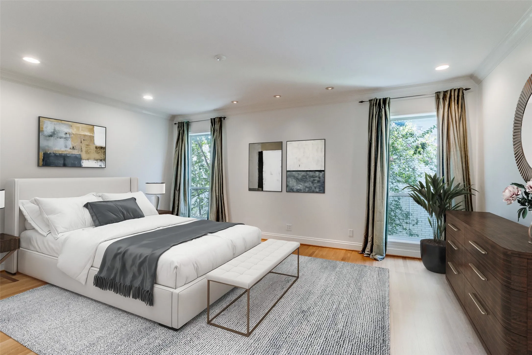 Large primary bedroom with high ceilings and wood floors.