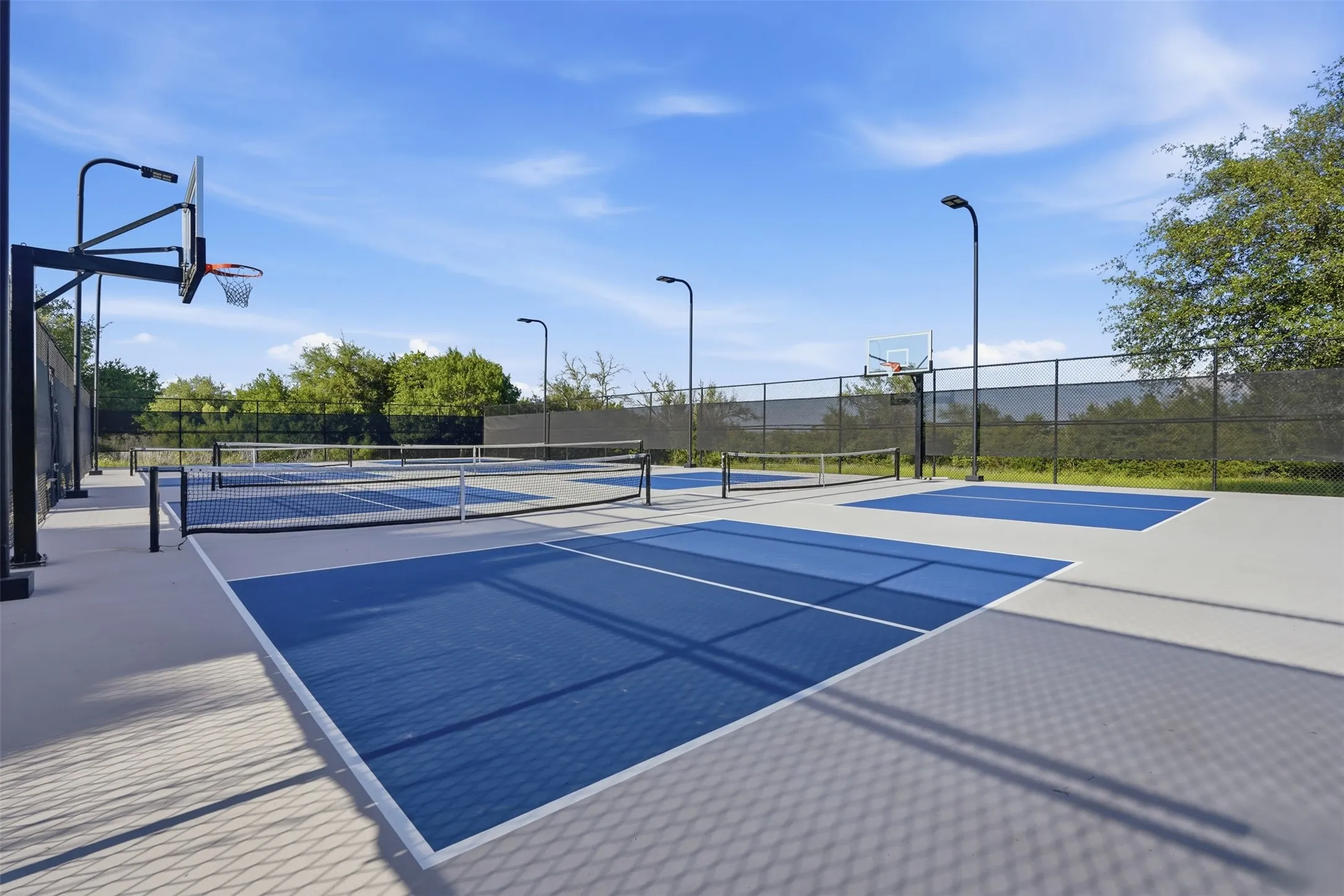 Recreational courts featuring multiple pickleball courts, tennis courts, and basketball hoops