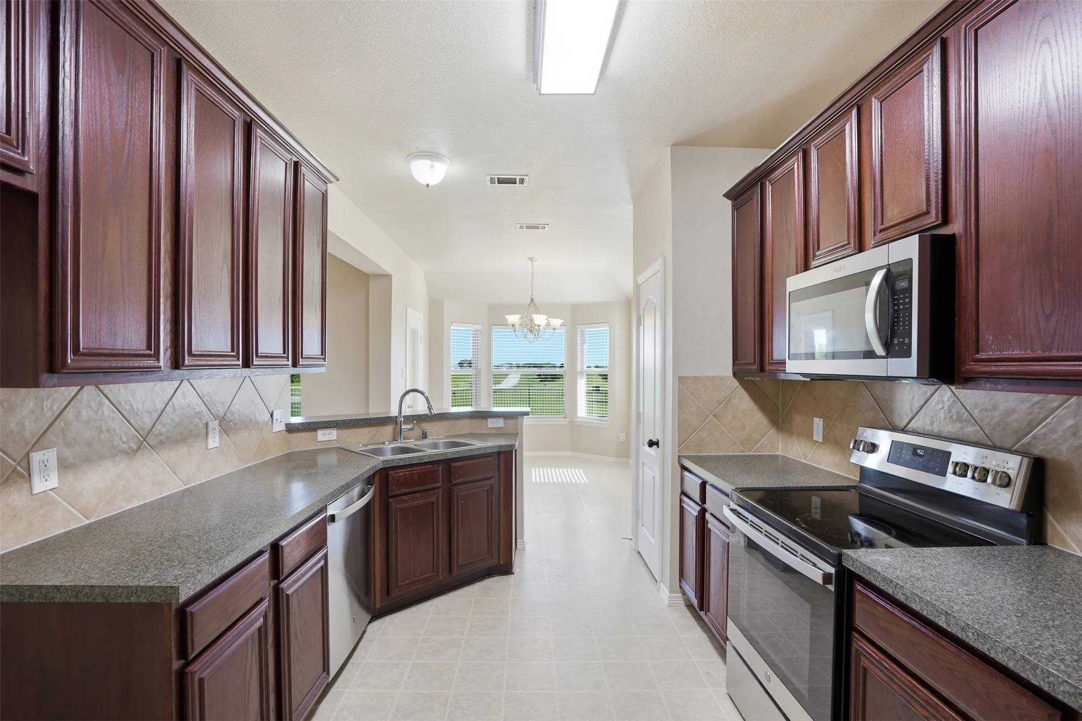Galley Kitchen with small dining area with bay window.