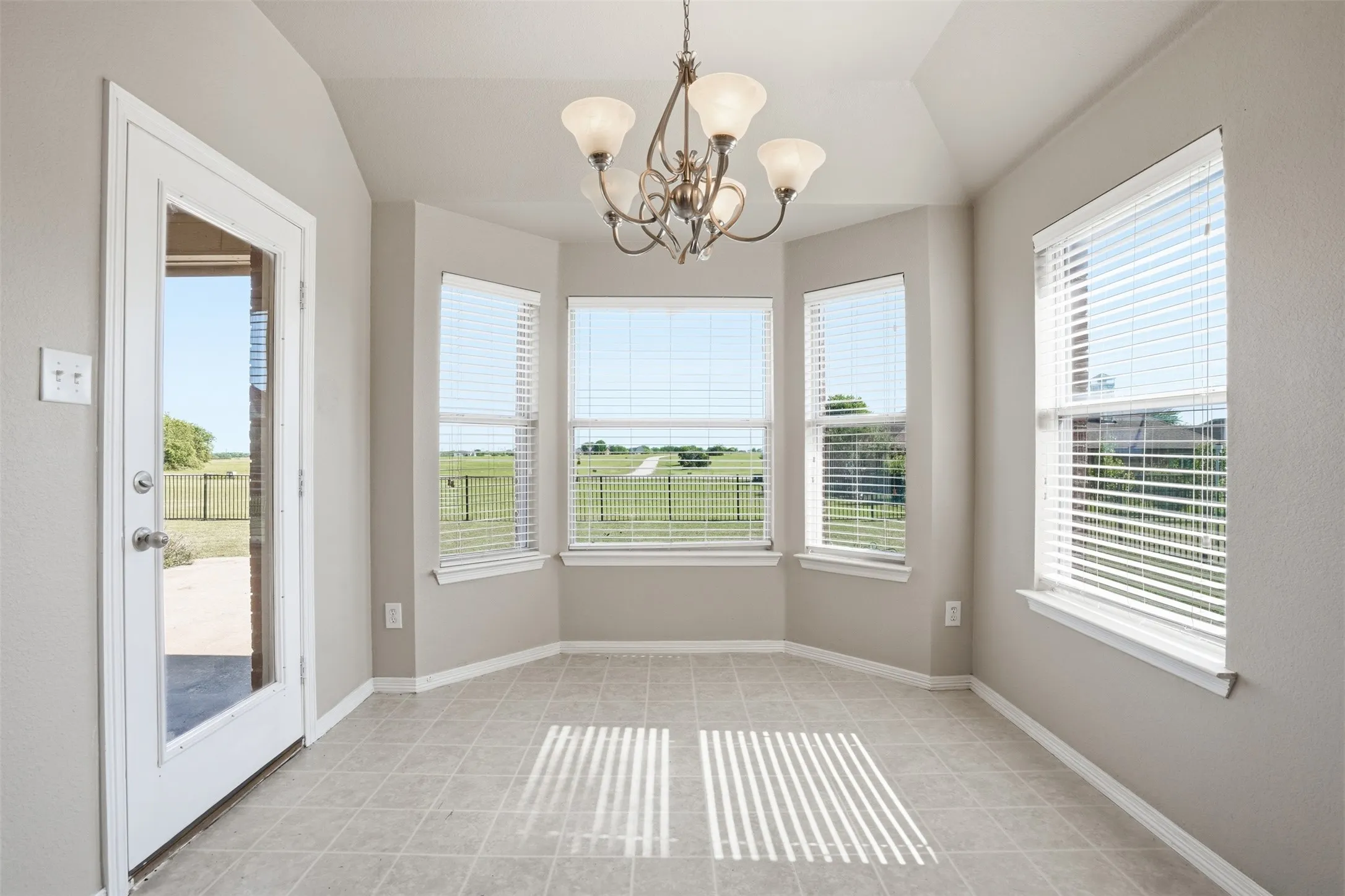 Small dining area in kitchen with bay windows that bring in bountiful light.